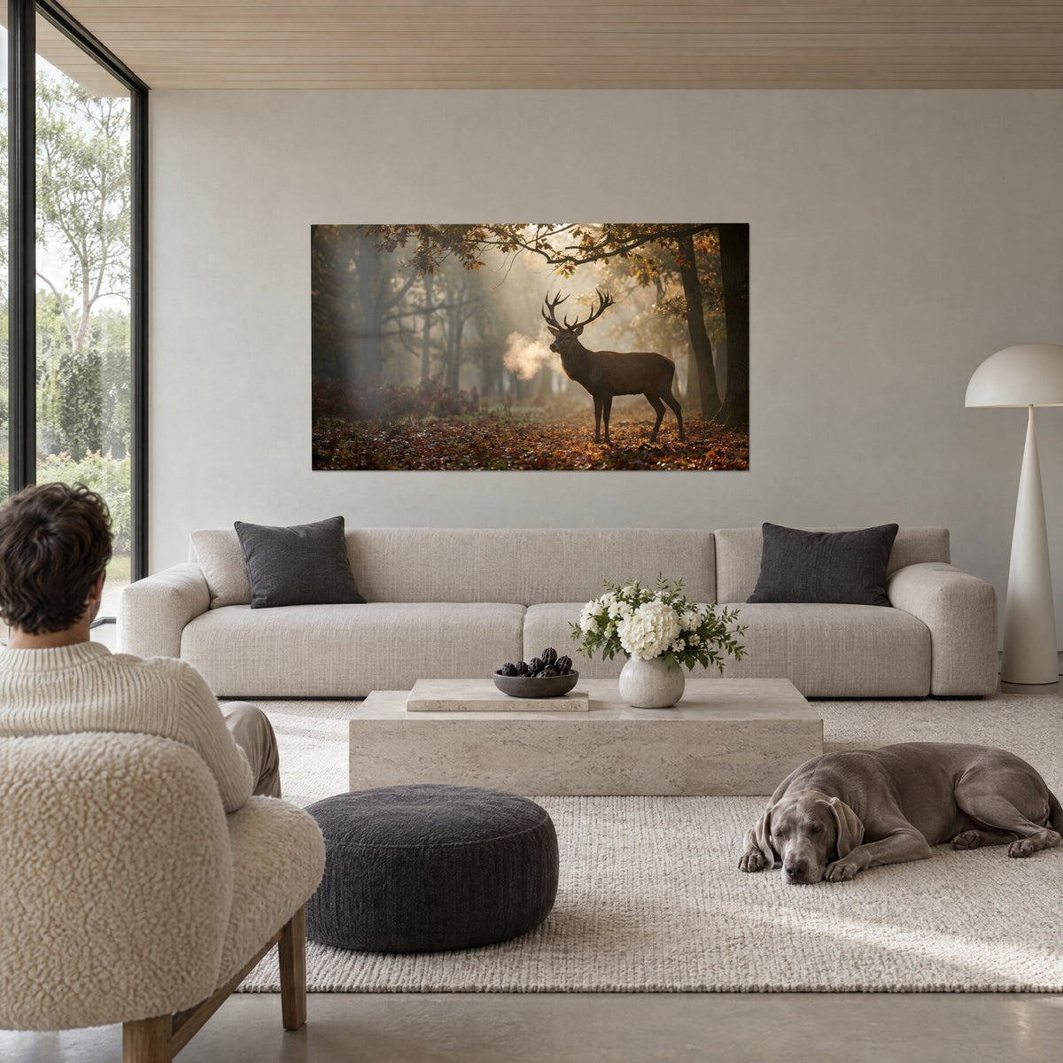 Tableau cerf élaphe aux bois ramifiés dans la brume dorée, roux et ocre, au-dessus d'un canapé dans un salon lumineux