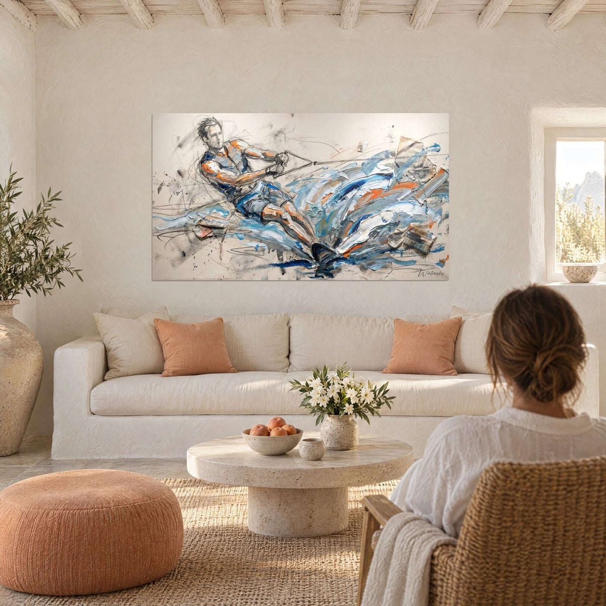 Wall art of a water skier pulling taut his rope, cobalt blue and bright orange splashes, above a sofa in a bright living room