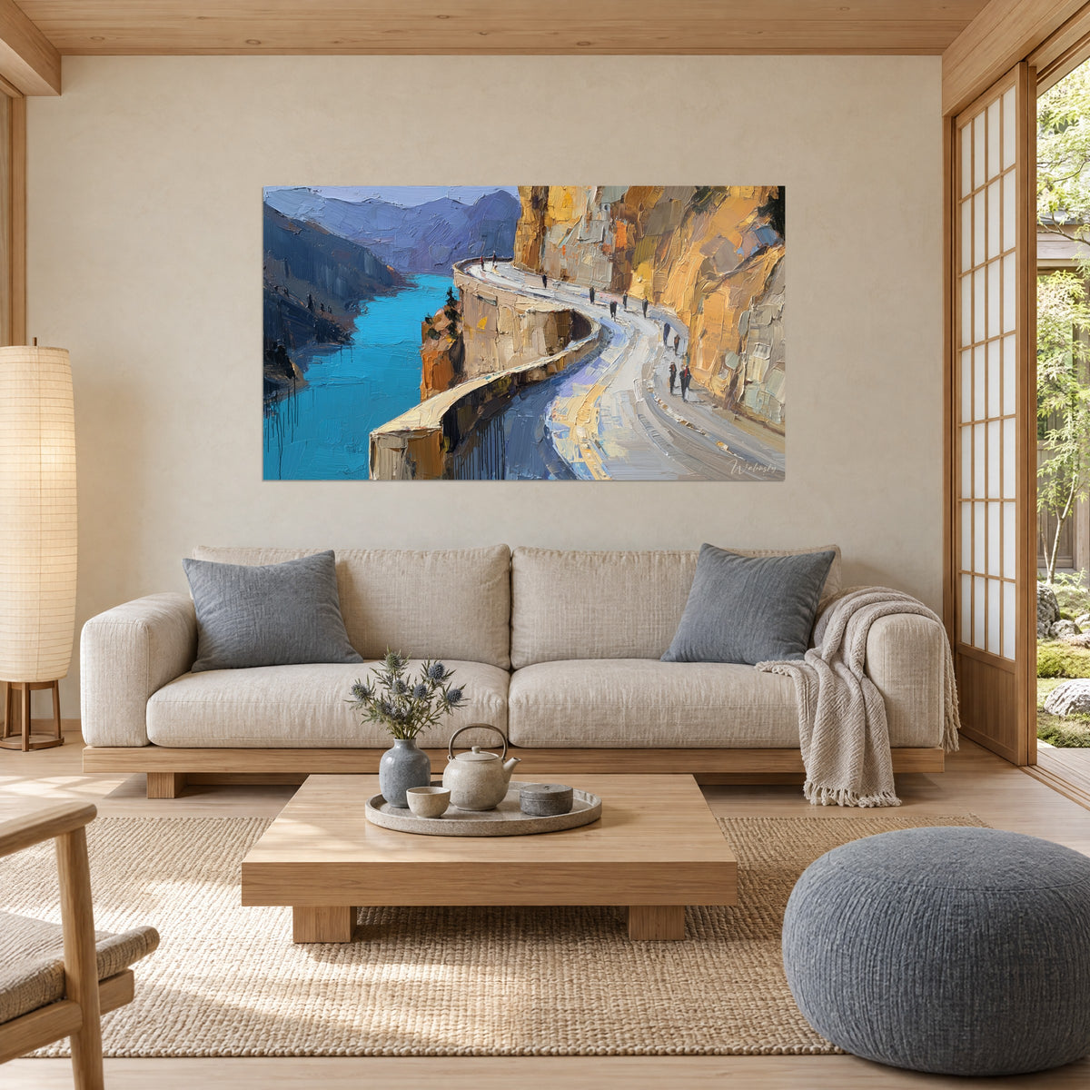 Tableau route sinueuse taillée dans une falaise ocre, lac turquoise en contrebas, au-dessus d'un canapé dans un salon lumineux