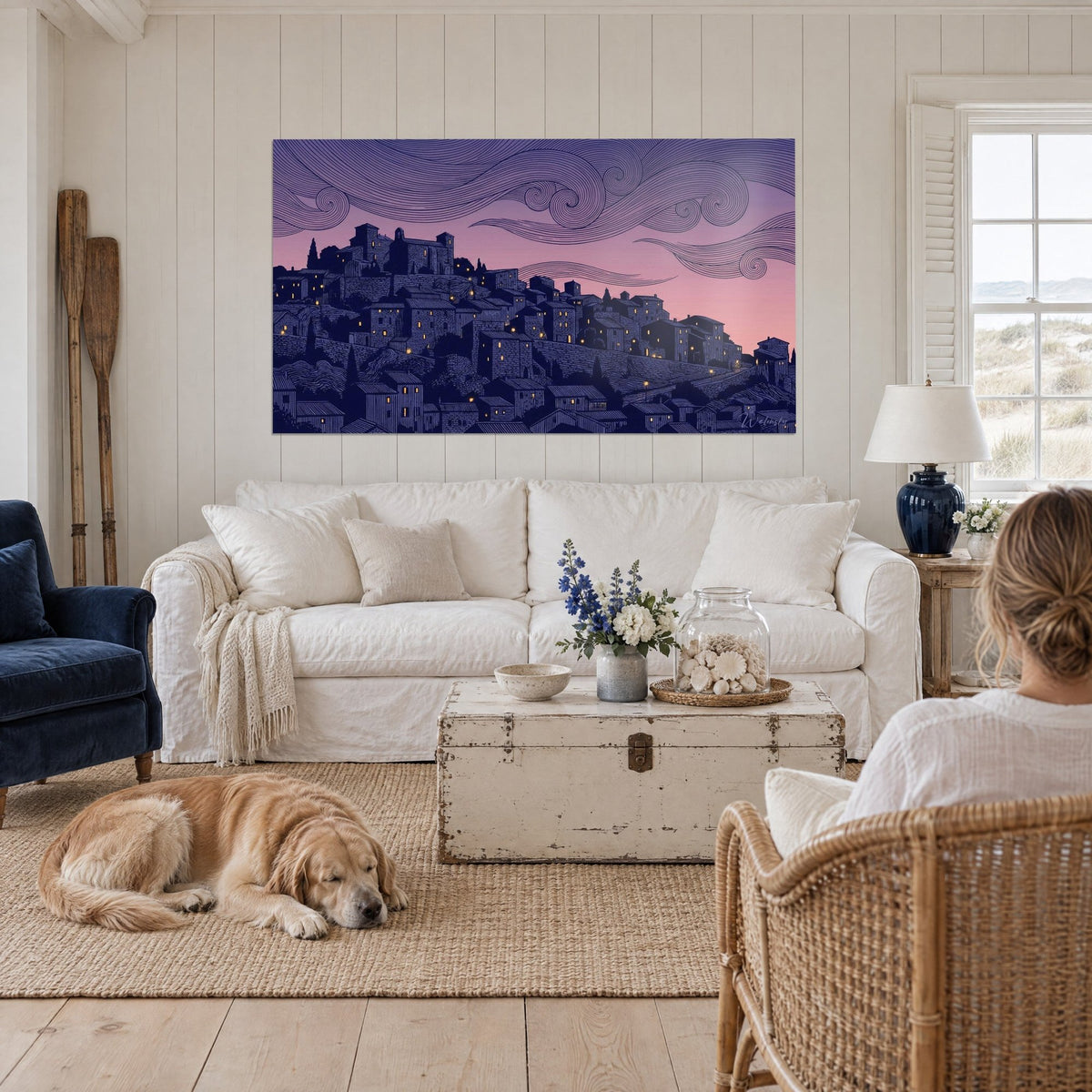 Quadro borgo arroccato a Les Baux-de-Provence in linoleografia, blu notte e rosa, finestre dorate, sopra un divano in un soggiorno luminoso