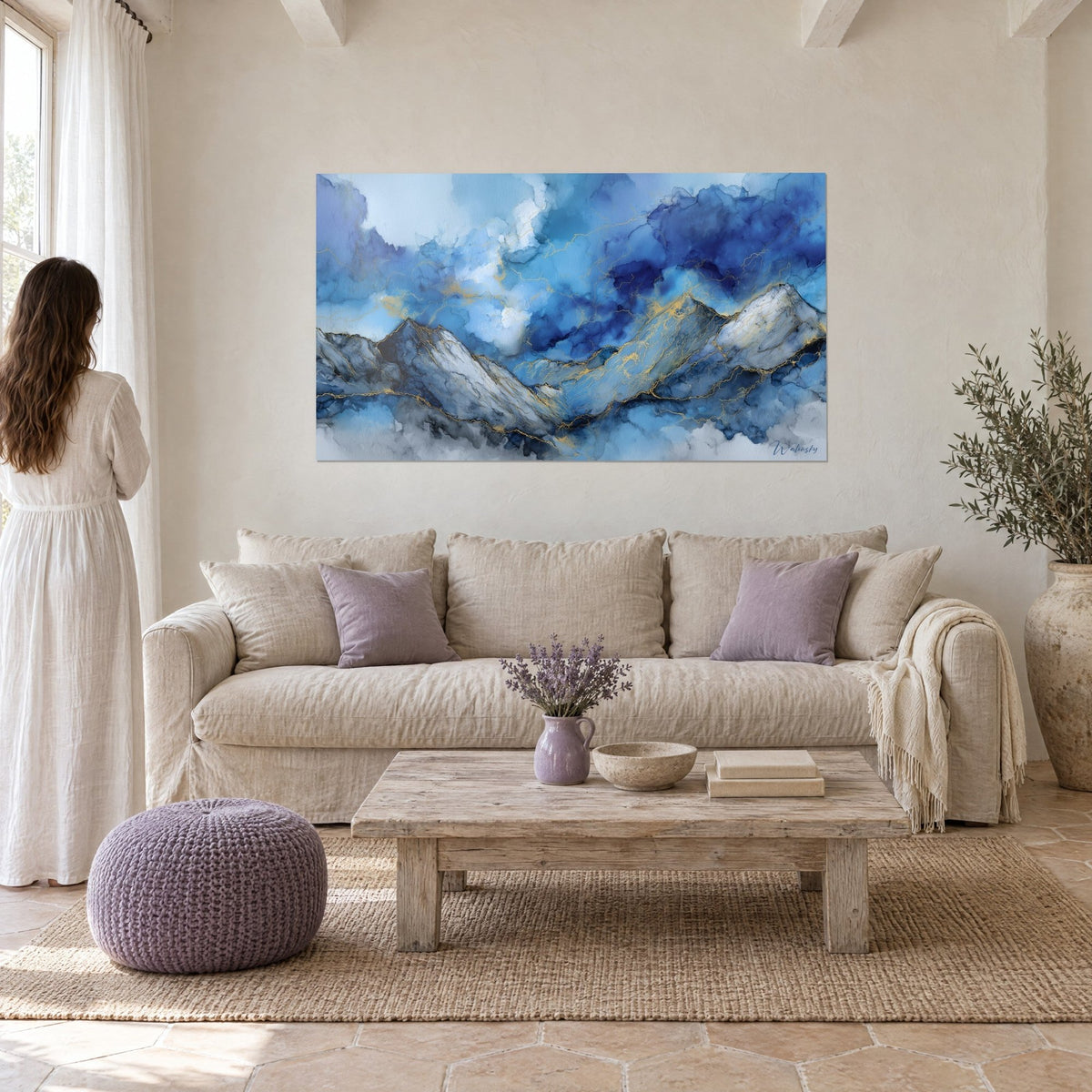 Wall art dolomite peaks with golden veins over cobalt blue and pearl grey clouds, woman seen from behind, above a sofa in a bright living room