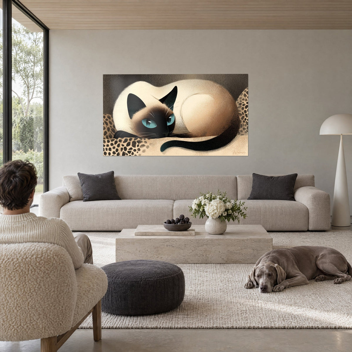 Schilderij opgerolde Siamese kat, bruin masker en turquoise ogen, crèmekleurige vacht op luipaardprint kussen, boven een bank in een lichte woonkamer