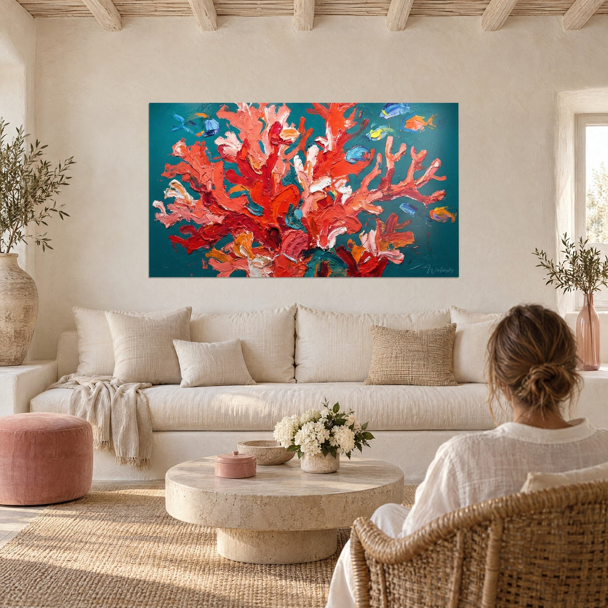 Wall art with raised red coral, scarlet impasto on a turquoise background, small blue fish, hung above a sofa in a bright living room