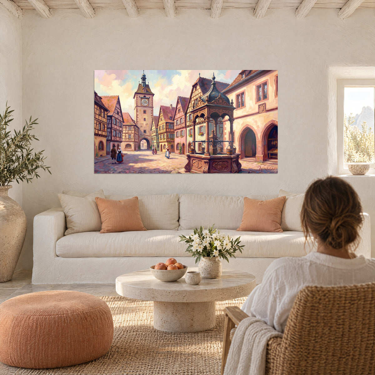 Gemälde alsatisches Dorf mit Fachwerkhäusern unter rosa und blauem Himmel, ockerfarbener geschnitzter Brunnen, über einem Sofa in einem hellen Wohnzimmer