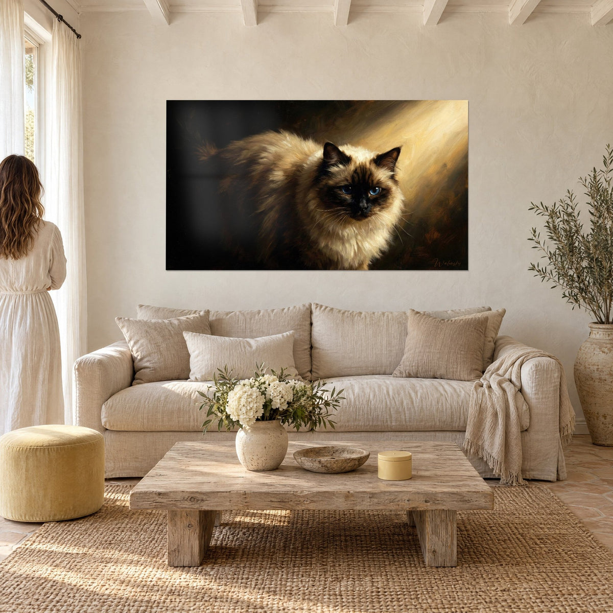 Schilderij Birmaanse kat met crèmekleurige en bruine vacht, doordringende blauwe ogen, gouden lichtstraal, boven een bank in een lichte woonkamer