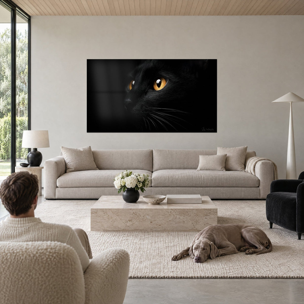 Gemälde schwarze Katze mit bernsteinfarbenen Iris und weißer Spiegelung in der Pupille, tiefschwarzer Hintergrund, über einem Sofa in einem hellen Wohnzimmer
