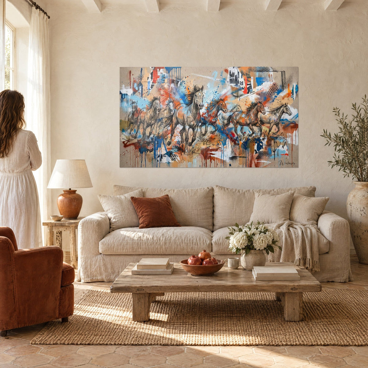 Quadro di cavalli selvaggi al galoppo, carboncino con schizzi azzurro cielo e arancio, appeso sopra un divano in un soggiorno luminoso