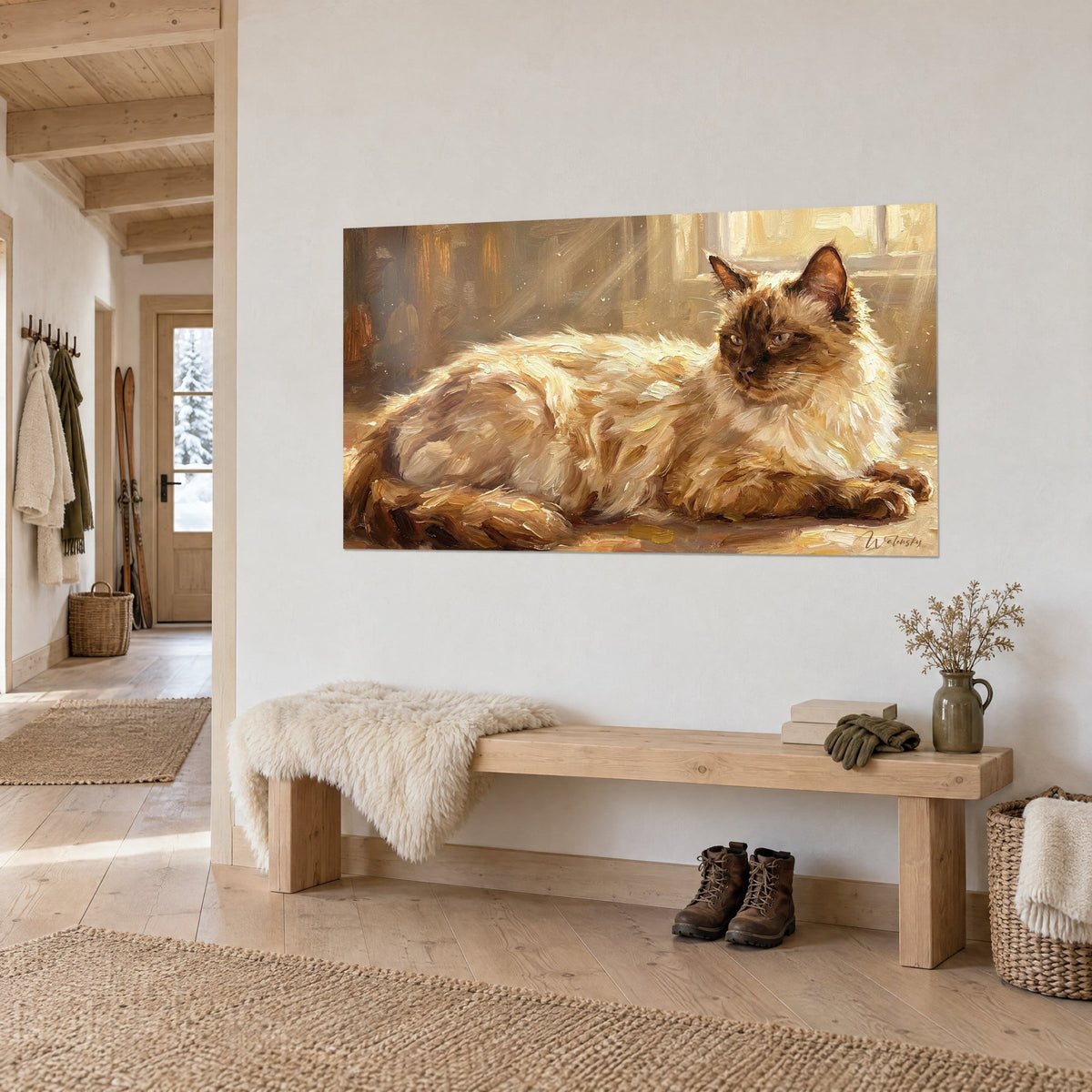 Quadro gatto Siamese dal pelo avorio e maschera cacao, sguardo rivolto di lato, su parete chiara accanto a una panca in legno nell'ingresso di uno chalet
