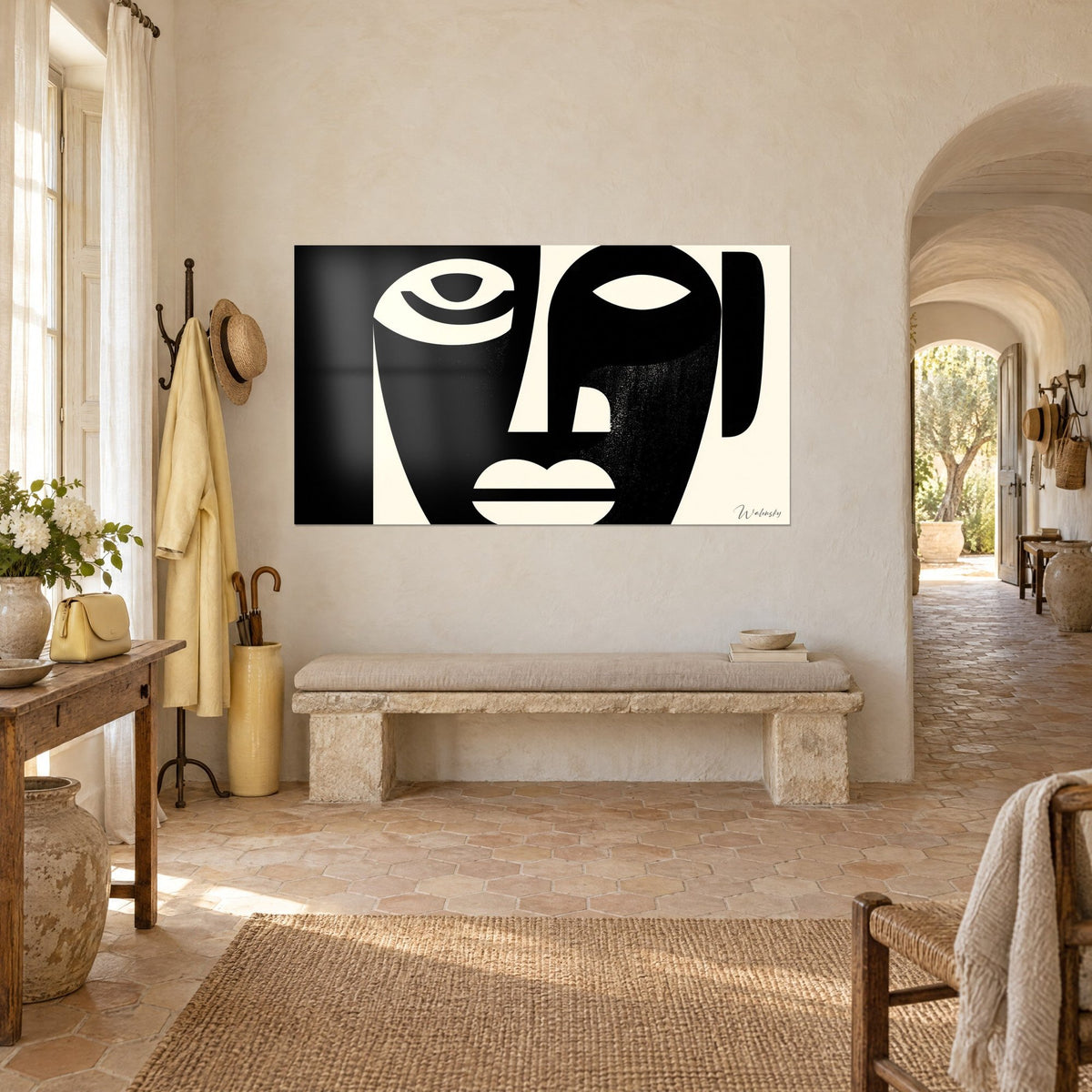Tableau visage géométrique en aplats noirs sur fond crème, nez fendu, oreille arrondie, vue de trois-quarts dans l'entrée du mas