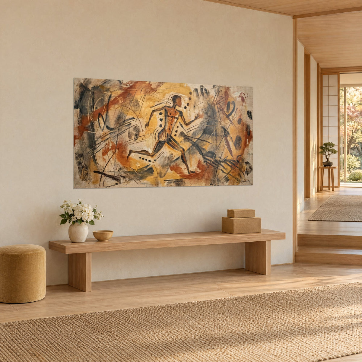 Quadro di una sagoma in salto in stile pittura rupestre, sfondo zafferano e grigio carbone, su una parete beige accanto a una panca in legno