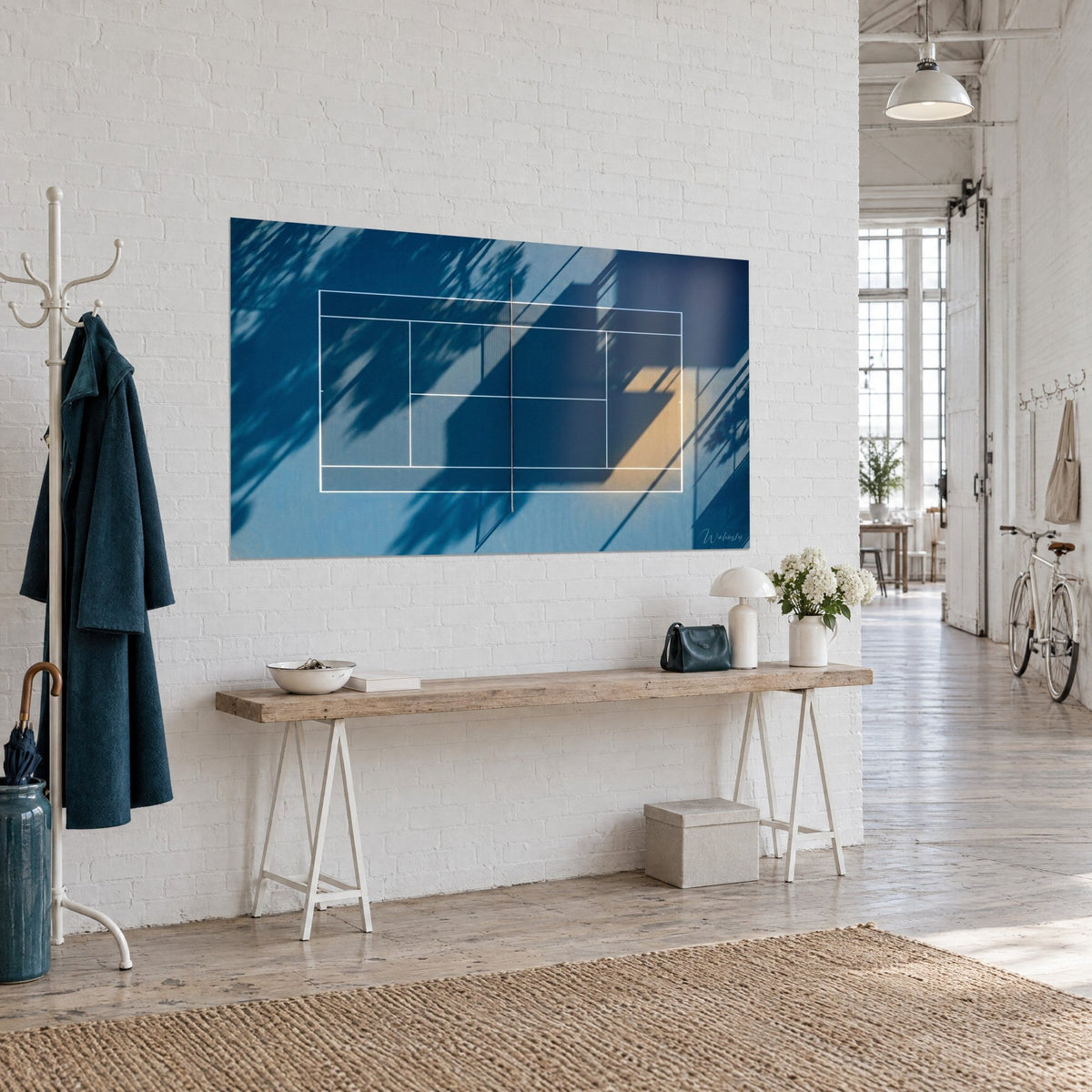 Schilderij nachtblauw baanvlak doorstreept met schaduwen, zwart net in het midden en gouden gloed in de hoek, opgehangen bij een houten console in een loft
