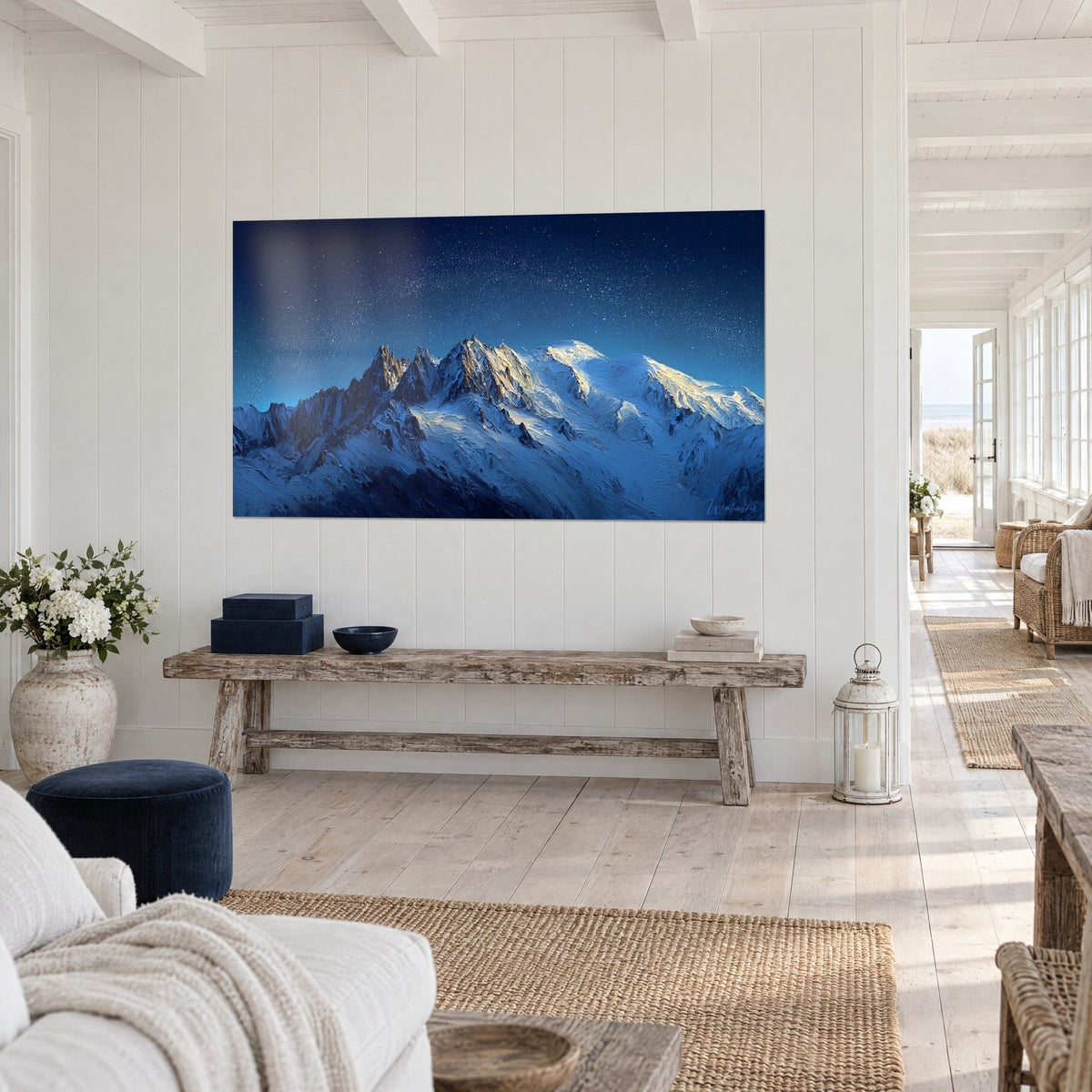 Cuadro agujas rocosas bajo un cielo estrellado, nieves azuladas y cumbres doradas, sobre una pared blanca revestida de paneles junto a un banco rústico