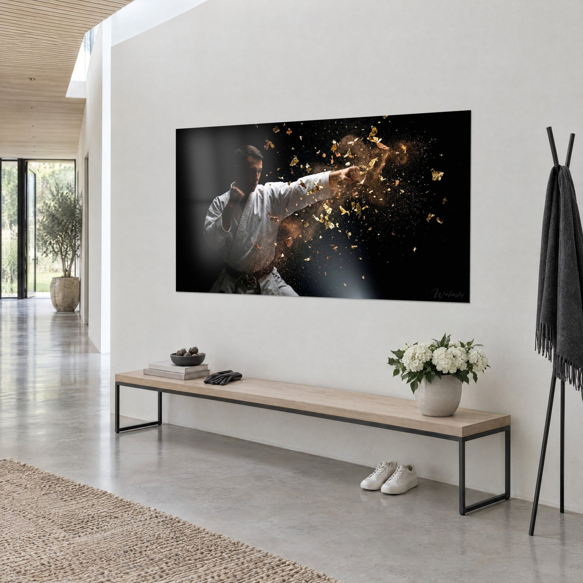 Tableau combattant en gi blanc frappant, éclats d'or et poussière cuivrée sur fond noir, mur clair près d'un banc en bois