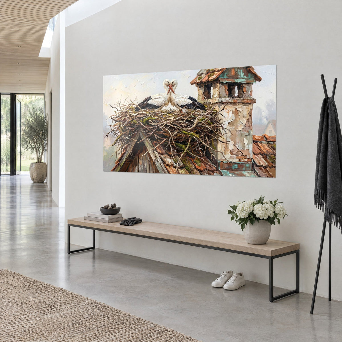 Tableau nid d'osier sec perché sur un toit, deux échassiers blancs et noirs, cheminée beige écaillée, au mur d'un séjour clair