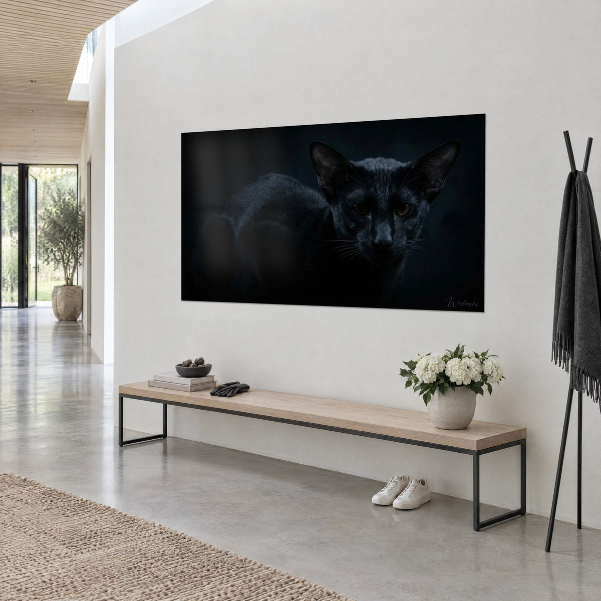 Cuadro de pantera en miniatura de terciopelo oscuro, ojos marrones fijos sobre fondo negro, pared blanca, consola de madera, en una casa de arquitecto, Walensky
