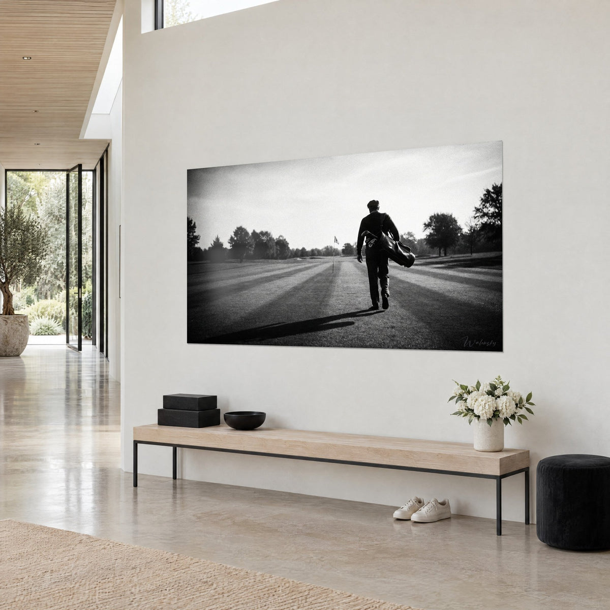 Schilderij met de silhouet van een golfer met platte pet die naar de vlag loopt, fluwelen zwart en stralend wit, aan de muur van een architectenwoning