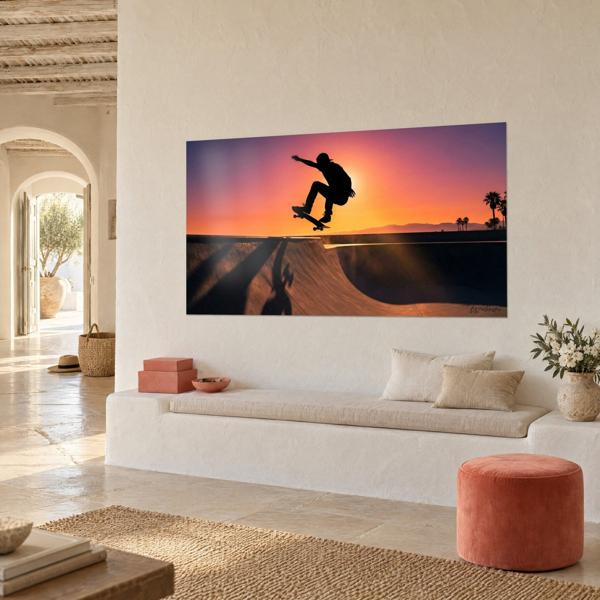 Gemälde schwarze Silhouette eines jungen Mannes beim Ollie, violetter und oranger Himmel, Palmen in der Ferne, an weißer Wand eines mediterranen Hauses