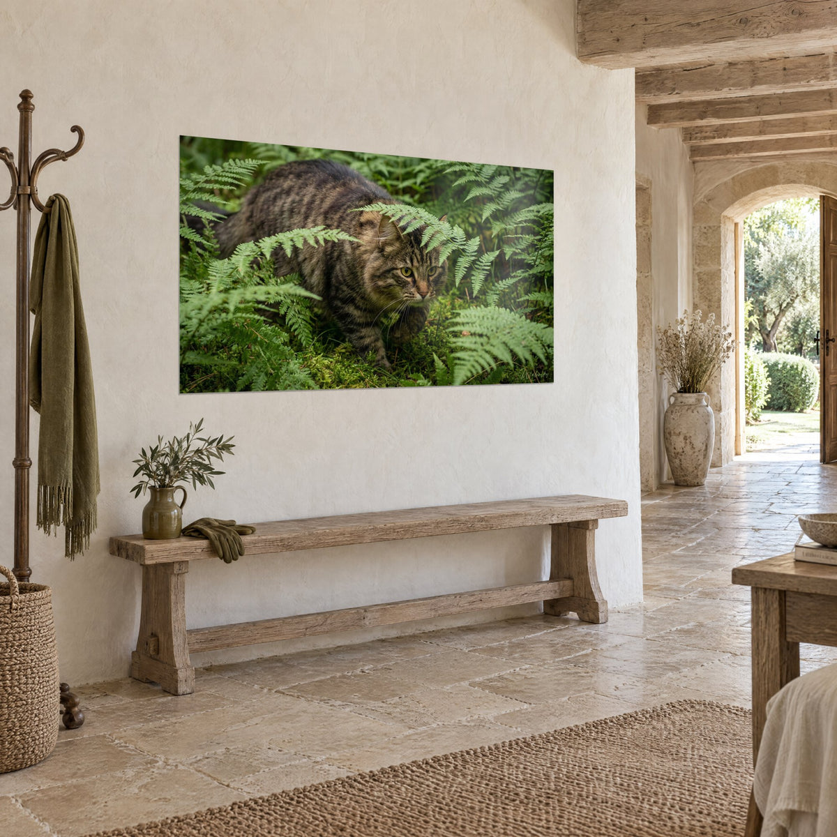 Wall art of a tigered wild cat on the hunt beneath soft green fronds, golden brown coat, beige rendered wall of a stone house