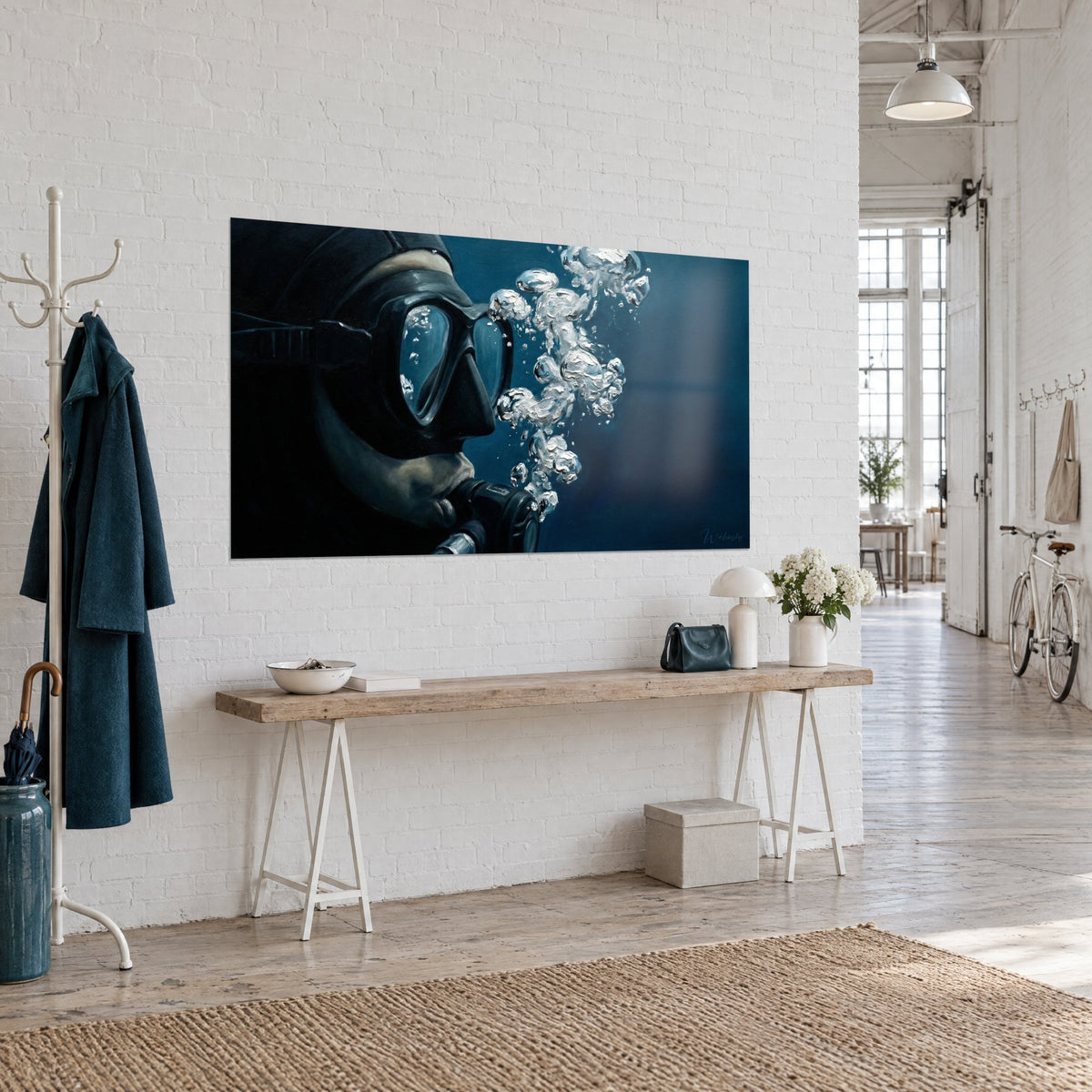 Wall art of a close-up scuba diver, silver bubbles rising through midnight blue water, white brick wall of an artist's loft