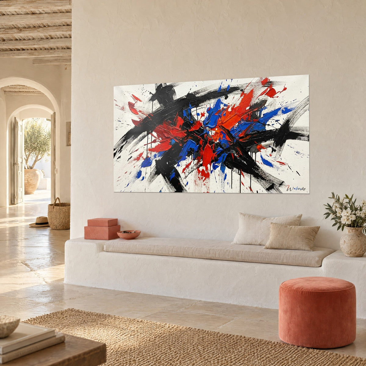 Wall art explosive canvas with thick red and blue impasto, black splashes on off-white, pale stone bench and coral pouf
