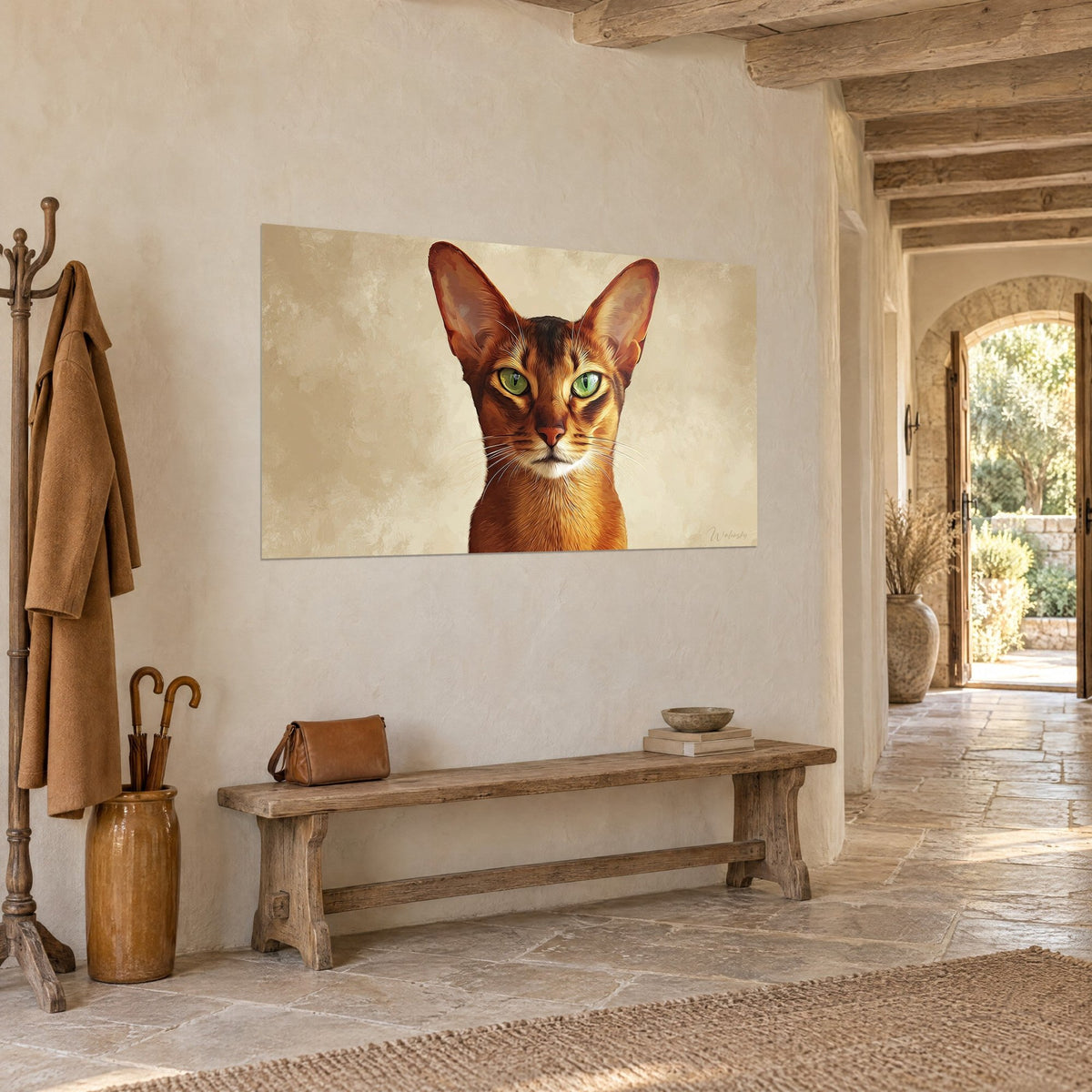 Cuadro gato rojizo con mirada esmeralda sobre fondo beige crema, frente a un banco de madera y un perchero, pasillo de piedra clara