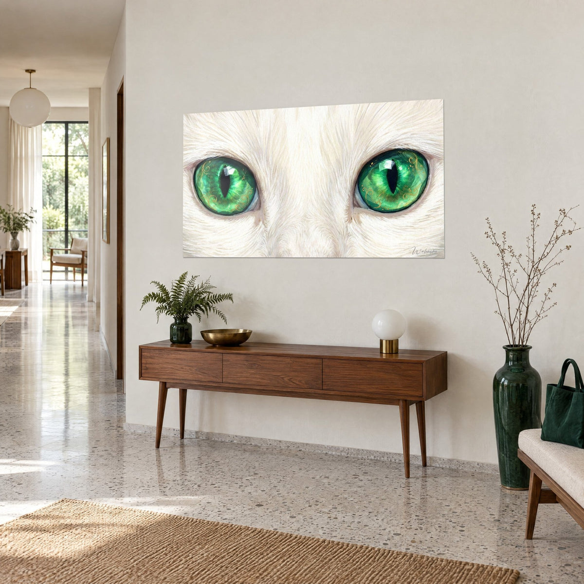 Tableau chat blanc aux iris verts facettés, pelage crème soyeux, accroché au-dessus d'un buffet en bois dans un couloir