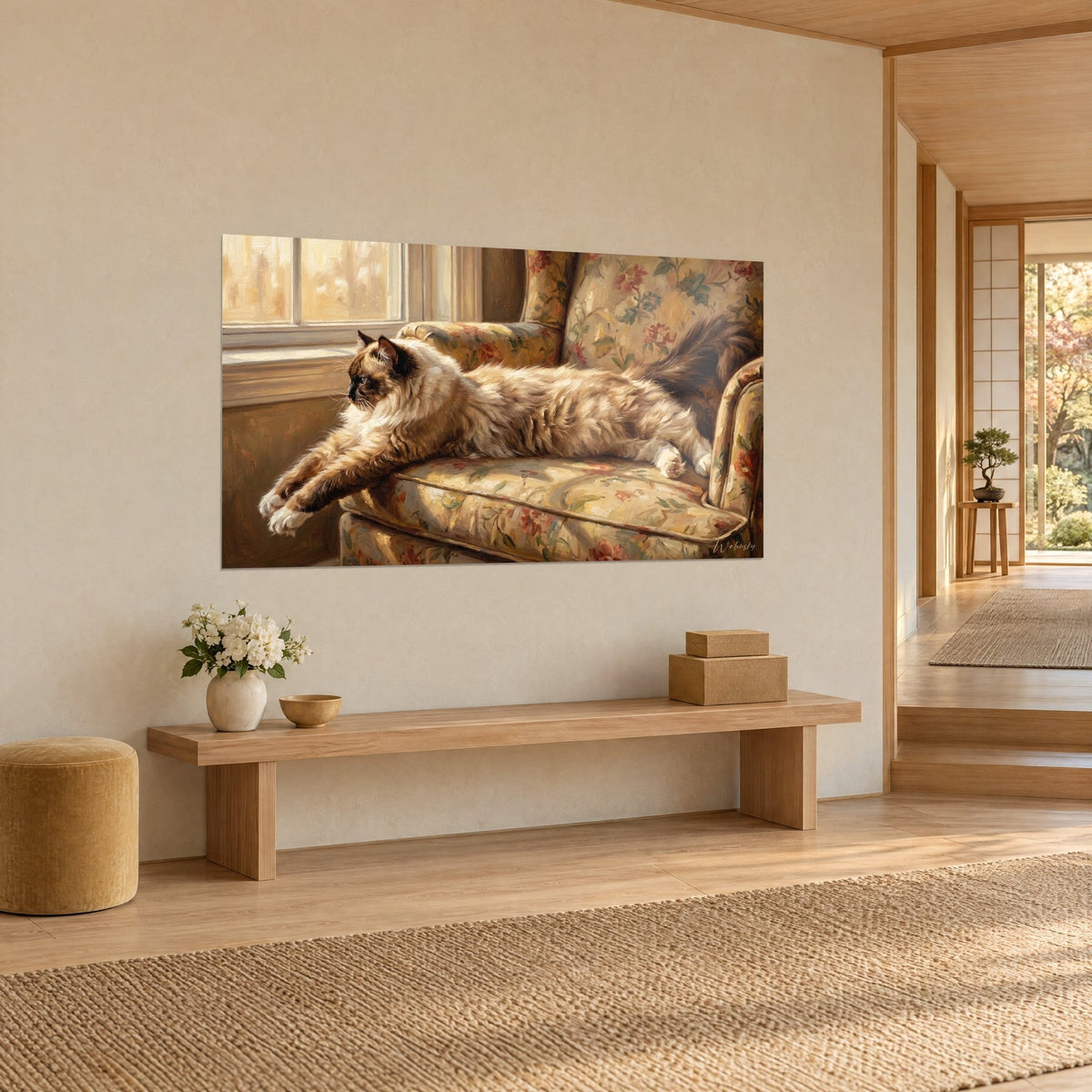 Wall art dark-masked feline lying on a cushion with red and beige flowers, angled view, light wood bench and vase of white flowers