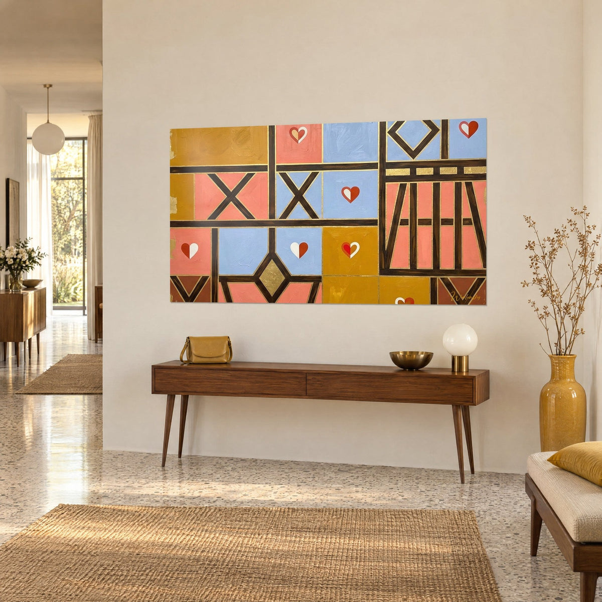 Wall art with a geometric mosaic of ochre, coral and periwinkle squares, brown St Andrew's crosses, on a beige wall above a wooden console