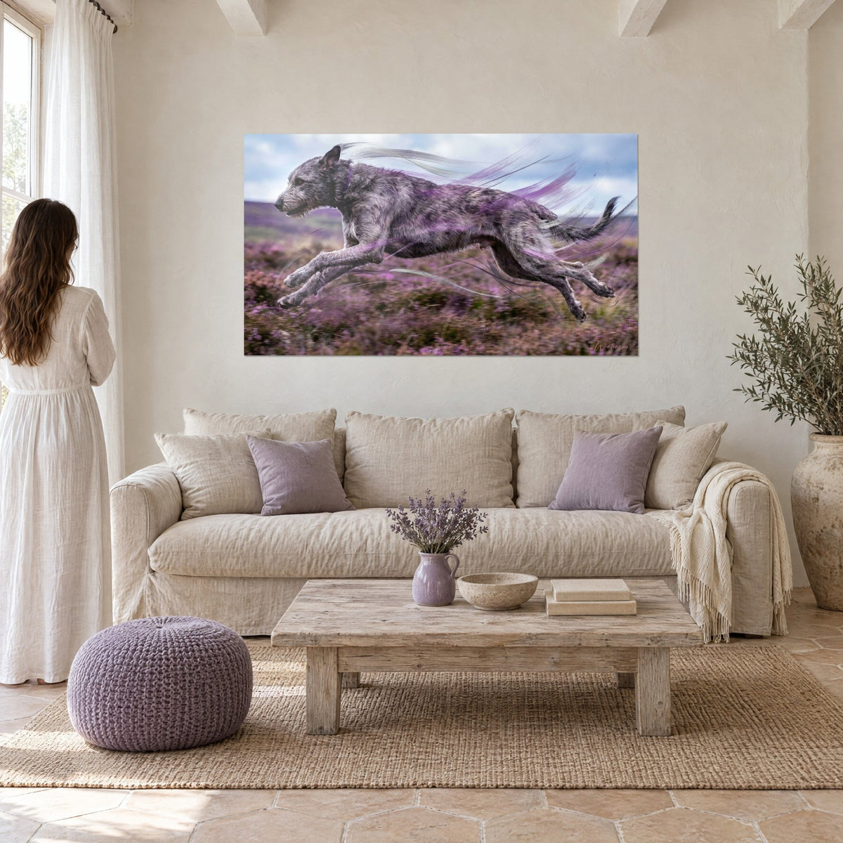 Wall art of an Irish wolfhound with grey coat bounding through purple heather, blue sky, above a sofa in a bright living room