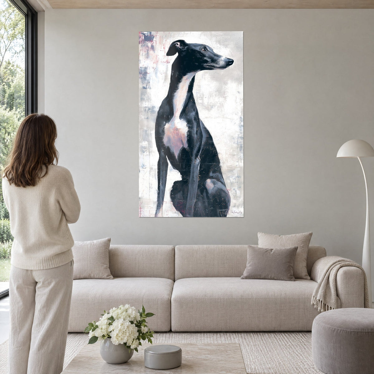 Wall art black greyhound sitting, white and pink chest, light grey scratched background, above a sofa in a bright living room