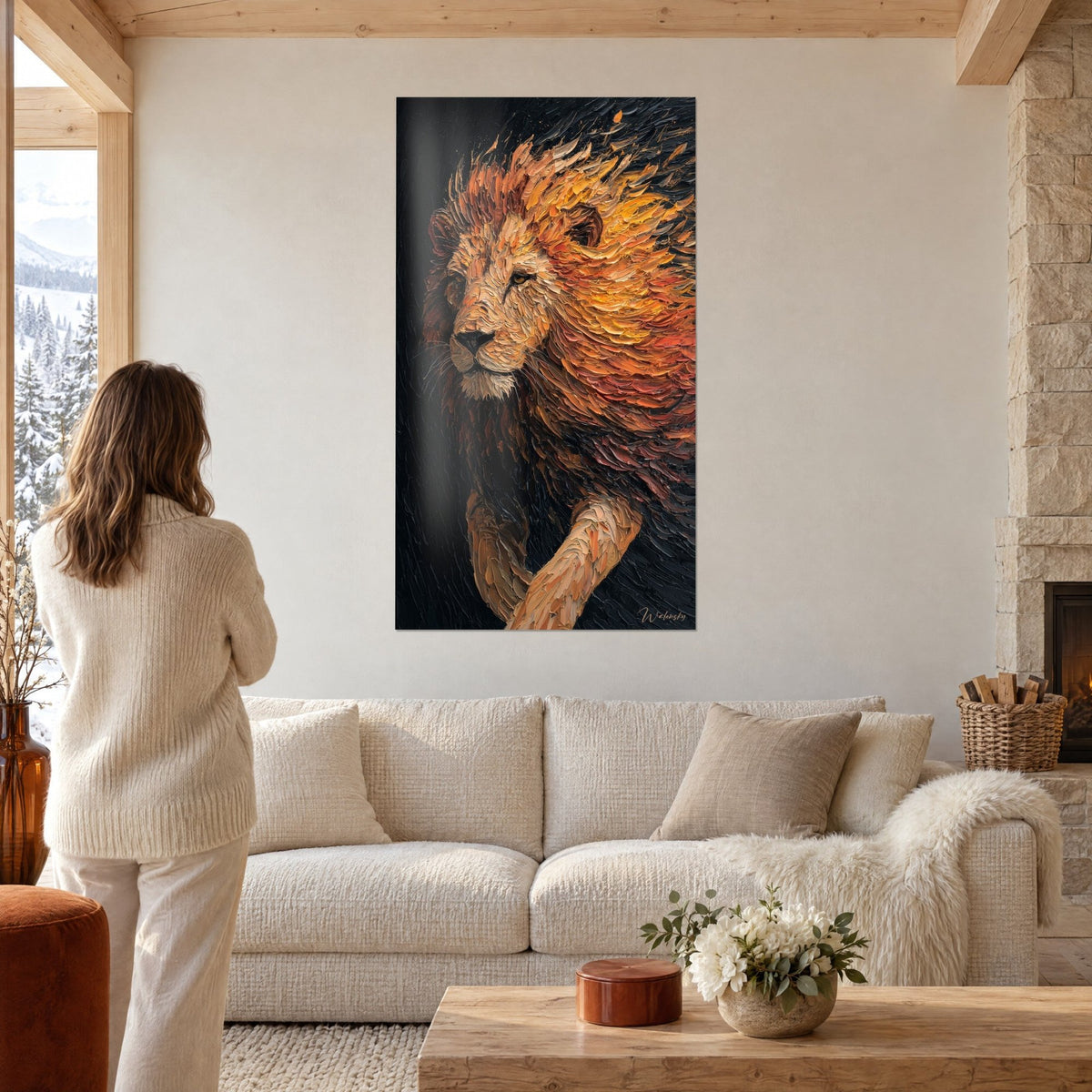 Schilderij majestueuze leeuw met vlammende oranje en gouden manen op zwarte achtergrond, vrouw van achteren, boven een bank in een lichte woonkamer