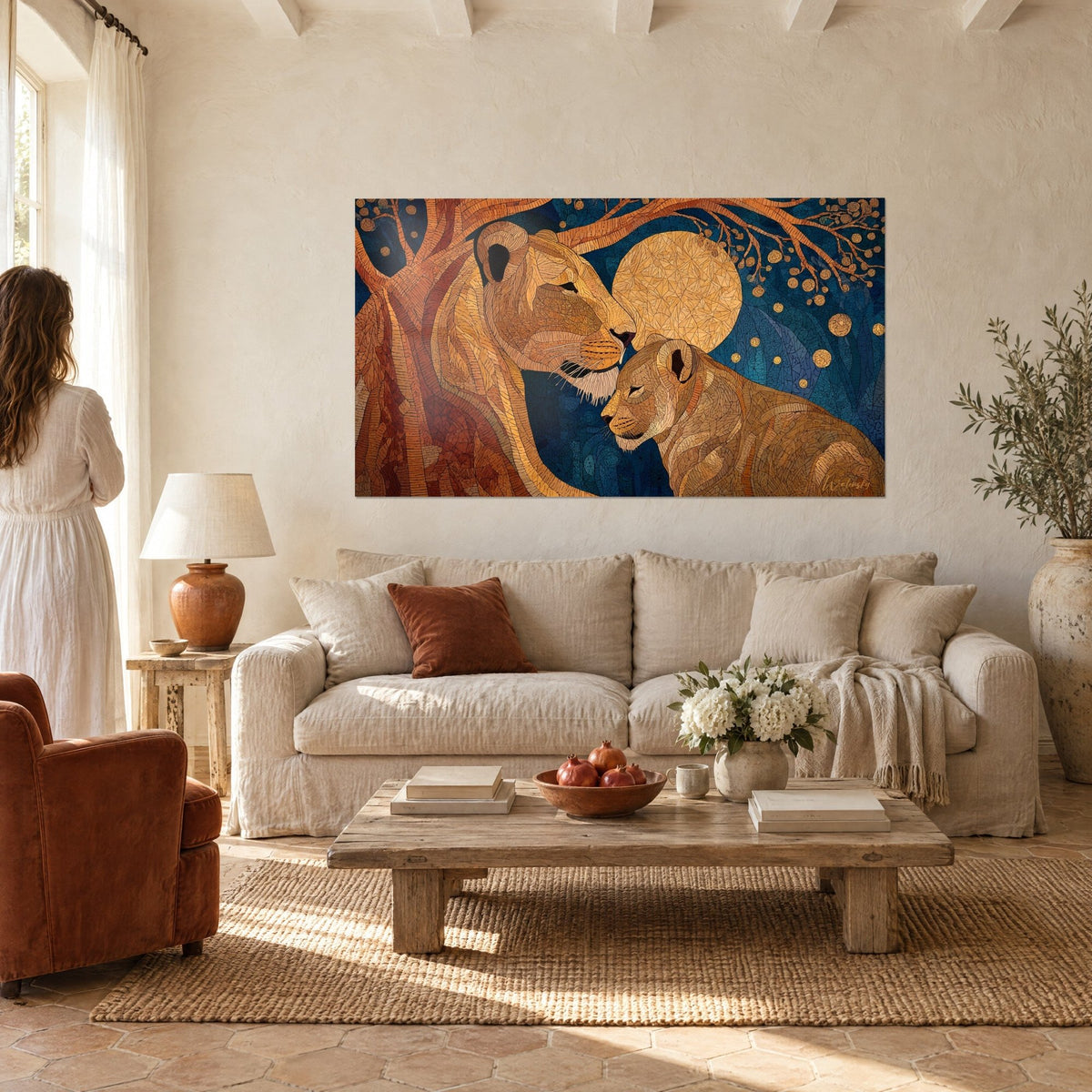 Schilderij gouden leeuwin die haar welp streelt onder een gouden maan, nachtblauwe achtergrond en koperen boom, boven een bank in een lichte woonkamer
