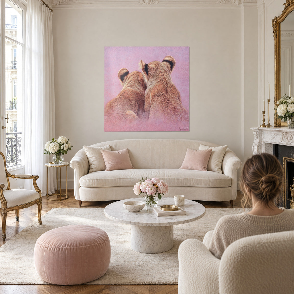 Schilderij twee leeuwenwelpen van achteren, vaalbruine en crèmekleurige vacht, op een poederroze achtergrond, boven een bank in een lichte woonkamer