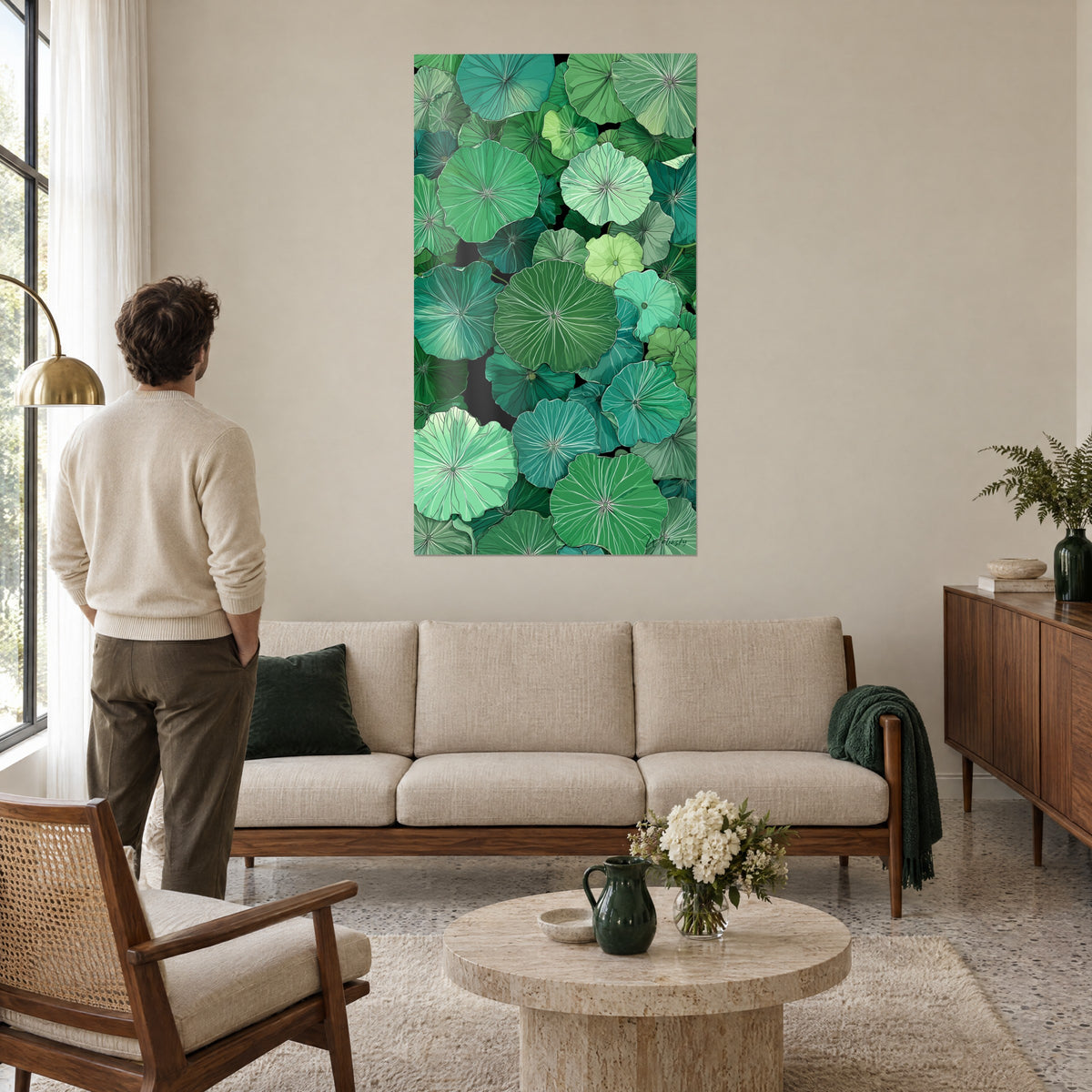 Wall art water lily leaves in emerald green and turquoise, radiating white veins, man seen from behind above a sofa in a bright living room