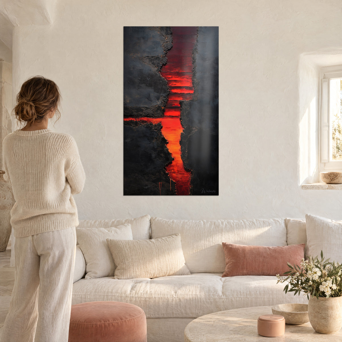 Gemälde glühender Riss, der eine kohlschwarze Wand durchzieht, orangefarbene und rote Adern, Frau von hinten über einem Sofa in einem hellen Wohnzimmer