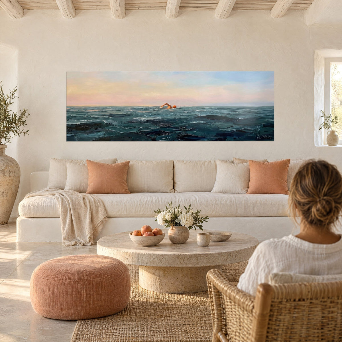 Tableau nageur au crawl, bonnet orange sur mer vert-de-gris, ciel rose et bleu, au-dessus d'un canapé dans un salon lumineux