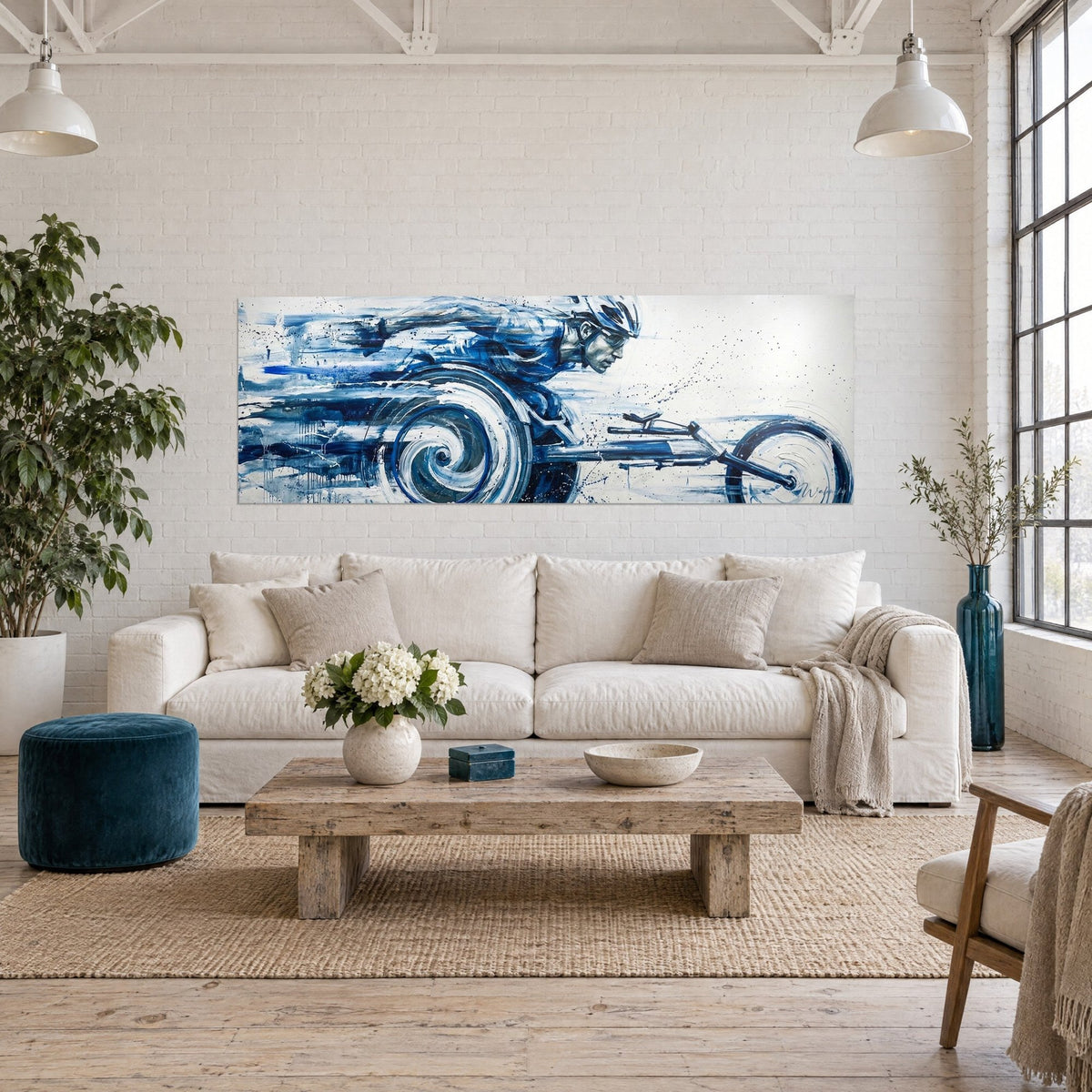 Wall art of a racing wheelchair athlete in full motion, cobalt blue and white, splashes, above a sofa in a bright living room