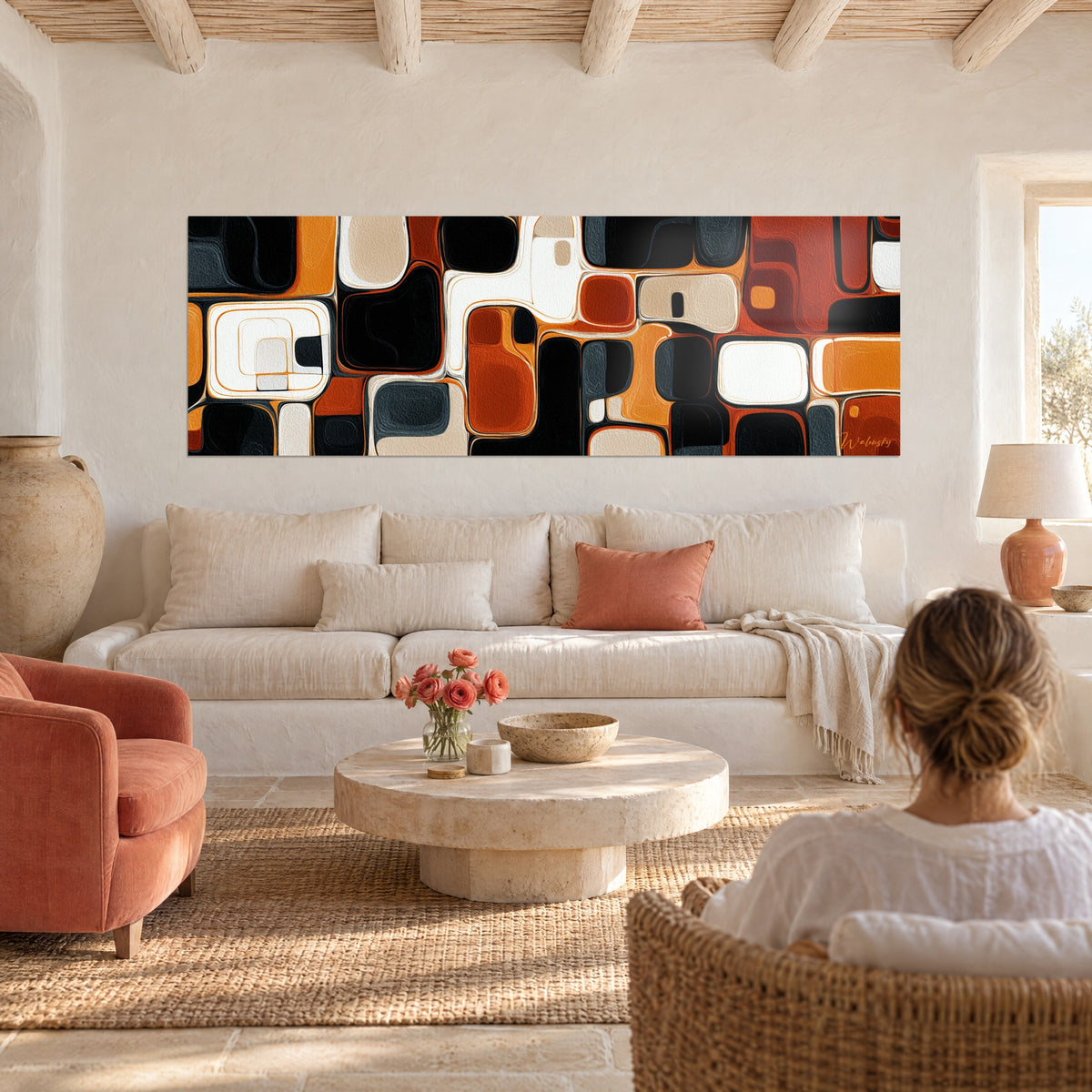 Wall art mosaic of rounded shapes in black, burnt orange and ivory, above a sofa in a bright living room
