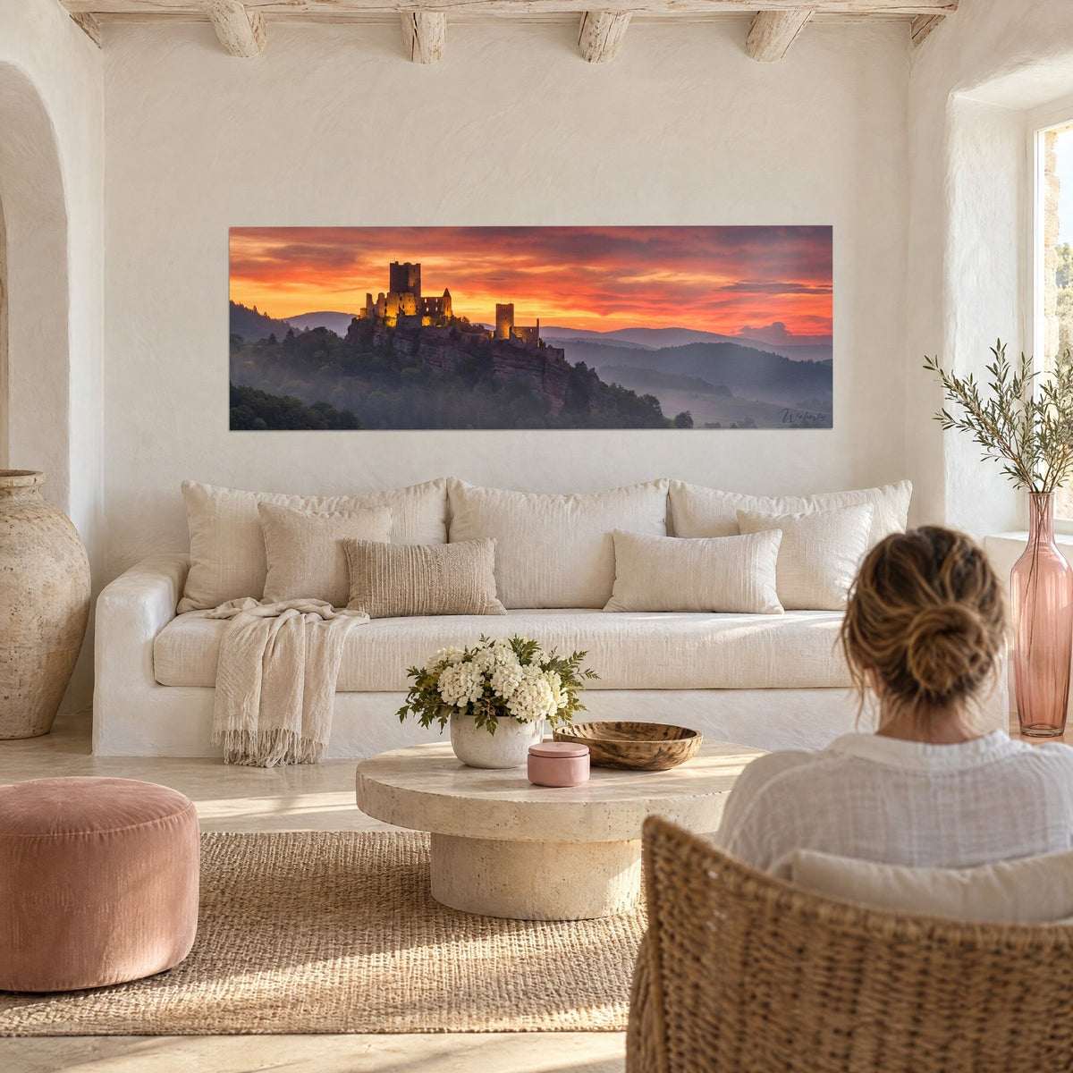 Tableau château fort en ruines éclairé d'or sur son éperon rocheux, ciel orange et rouge, au-dessus d'un canapé dans un salon lumineux