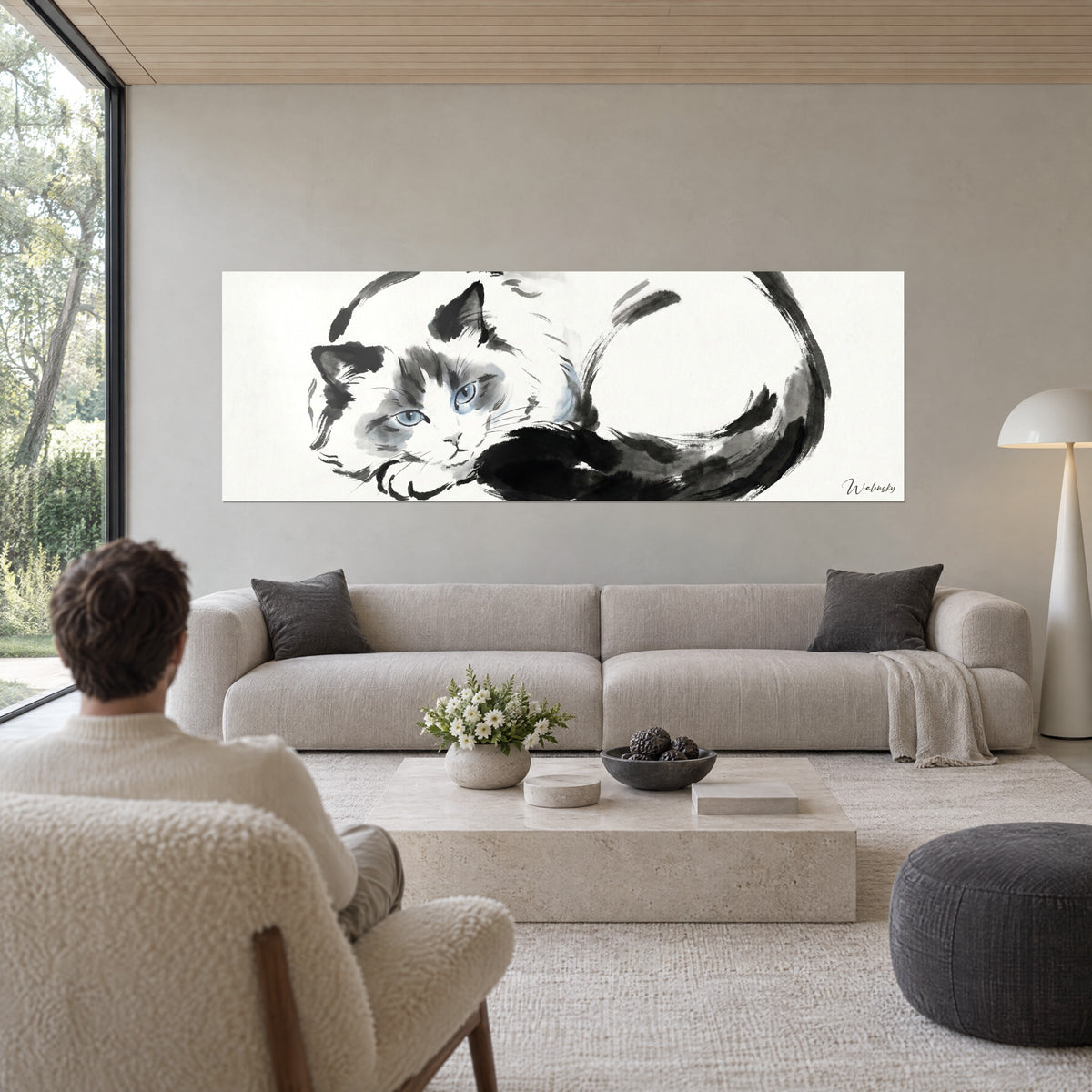 Tableau chat ragdoll en encre noire et lavis bleu pâle, yeux azur, queue enroulée sur fond ivoire, au-dessus d'un canapé dans un salon lumineux