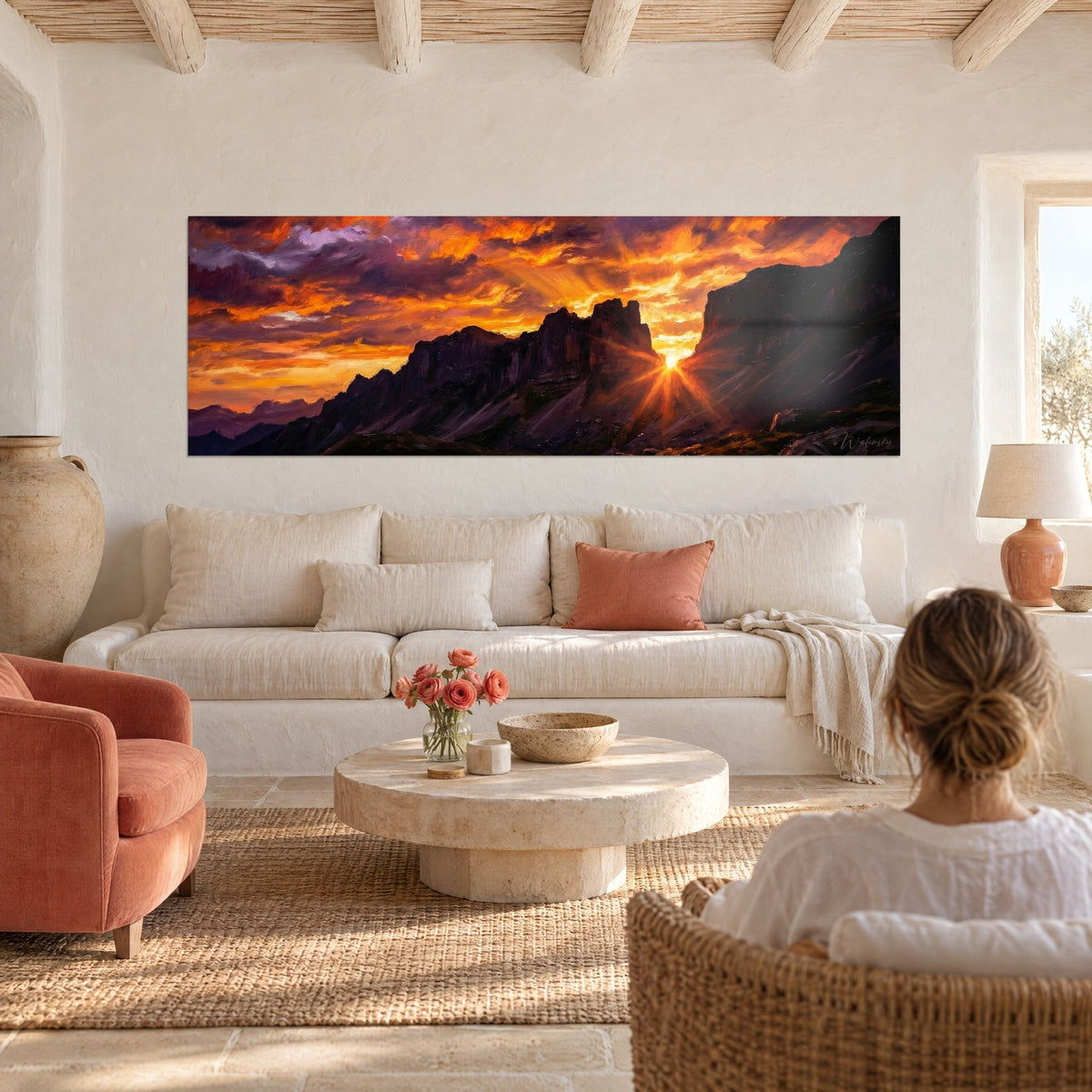 Wall art blazing Pyrenees ridge, orange starry sun and violet sky, a woman seen from behind, above a sofa in a bright living room