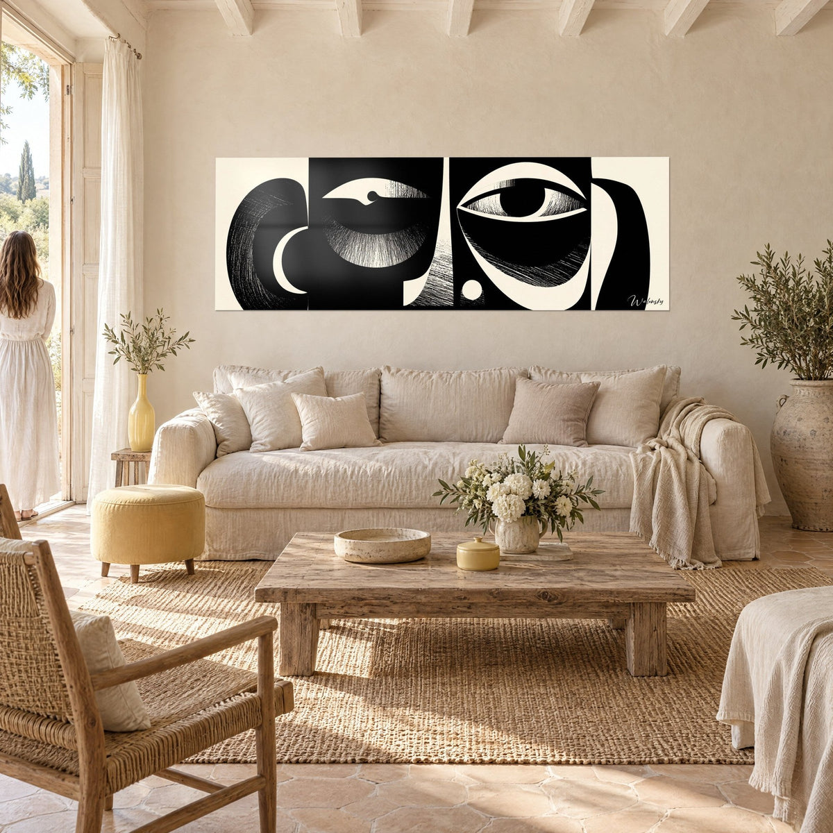 Tableau masque africain stylisé en noir et crème, œil ouvert et arcs rayés, au-dessus d'un canapé dans un salon lumineux