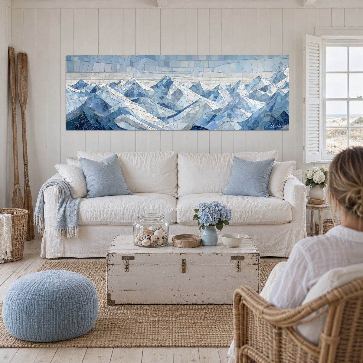 Wall art alpine peaks in a mosaic of glacier blue and pearly white, triangular shards, above a sofa in a bright living room