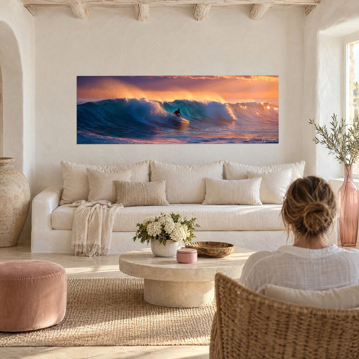 Gemälde Surfer als Silhouette, der durch eine türkisfarbene Welle gleitet, orangefarbener und rosa Himmel, über einem Sofa in einem hellen Wohnzimmer