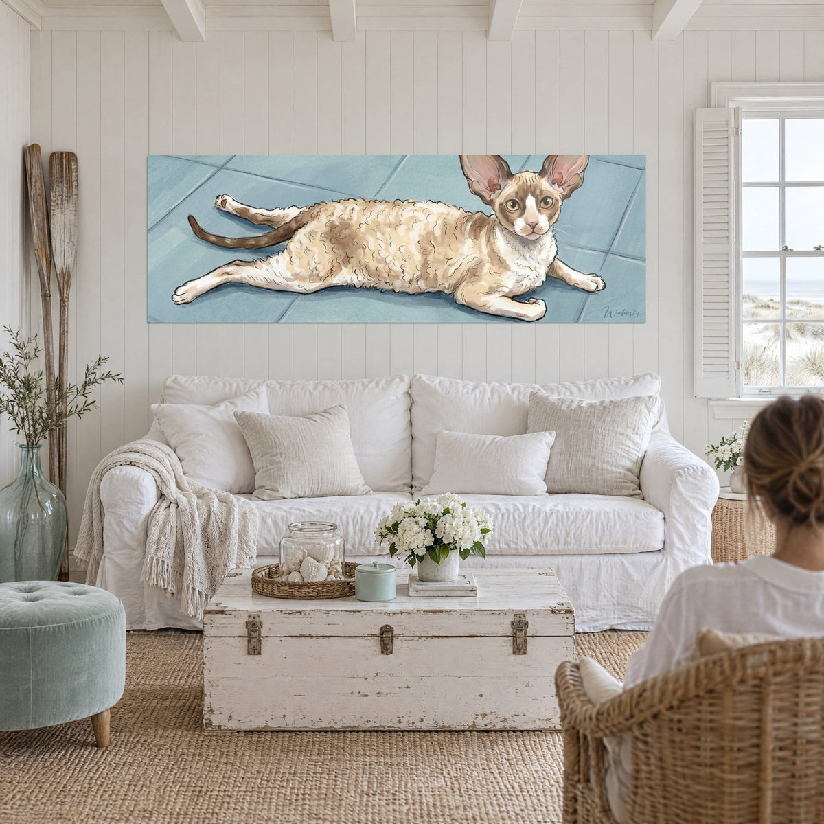 Quadro di un gatto Cornish Rex sdraiato, pelo riccio crema e caramello, su piastrelle blu, sopra un divano in un soggiorno luminoso