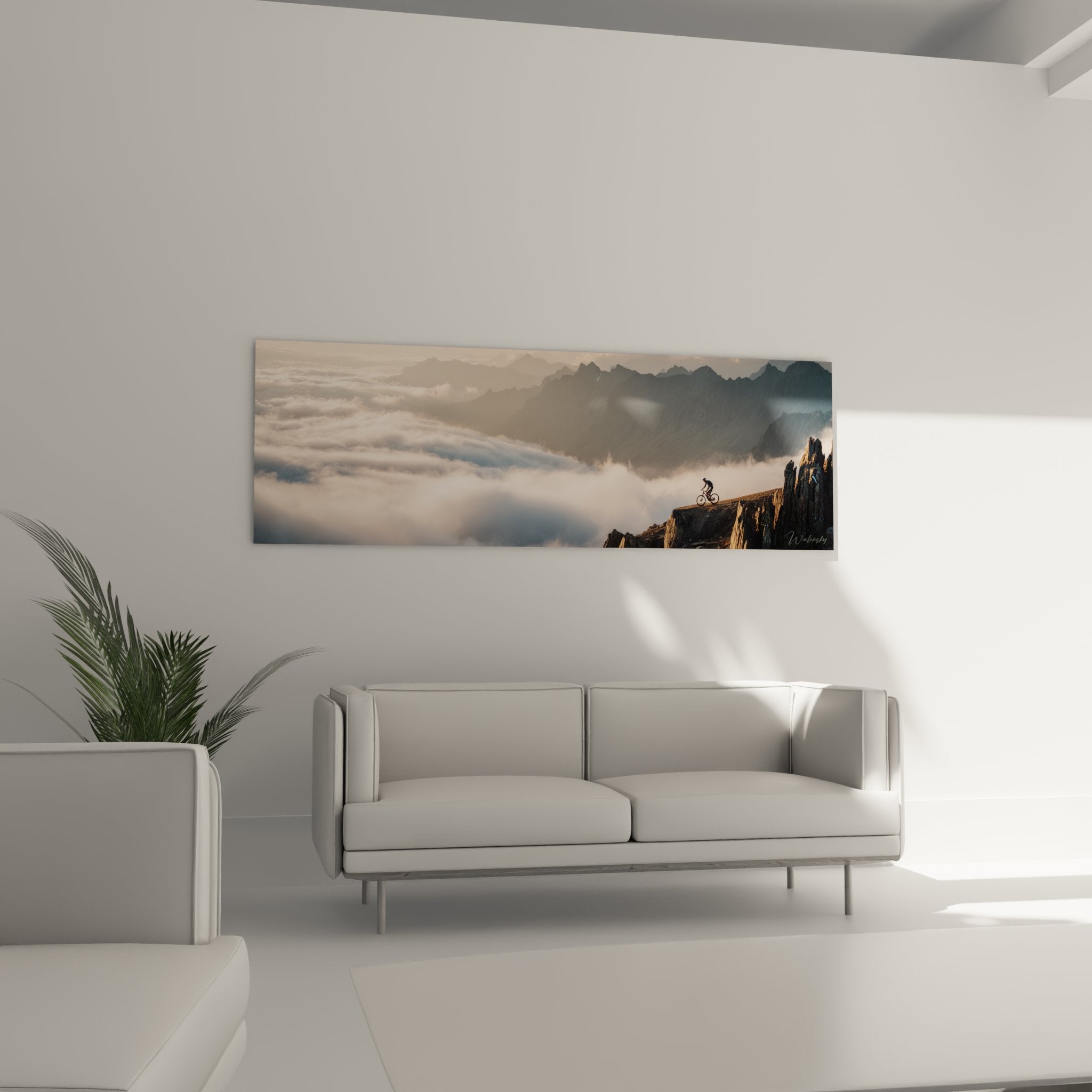 Detail tableau VTT montrant cycliste silhouette sur rocher avec panorama nuageux et pics montagneux