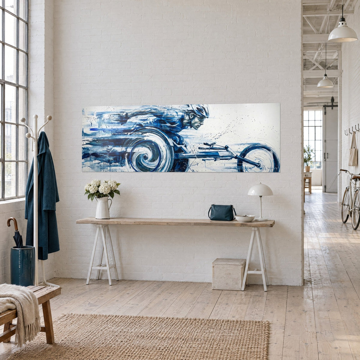 Wall art of a helmeted handbike rider speeding through an indigo and white swirl, paint streaks, hung on a light loft wall