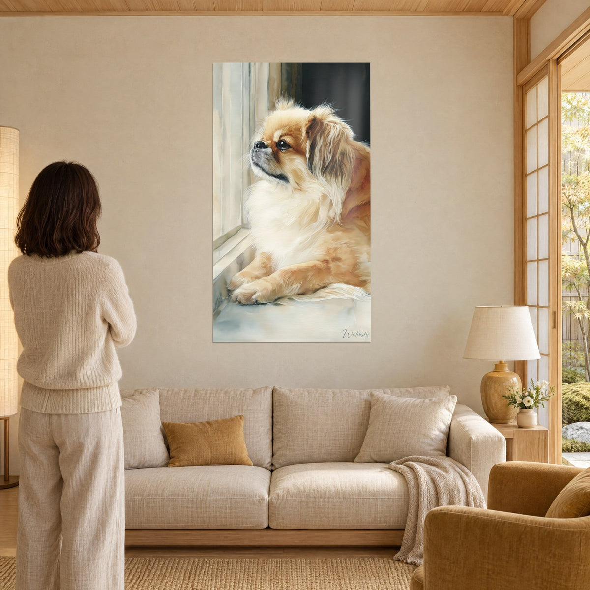 Cuadro perro pequinés crema y bermejo asomado a la ventana, mujer de espaldas, sobre un sofá en un salón luminoso