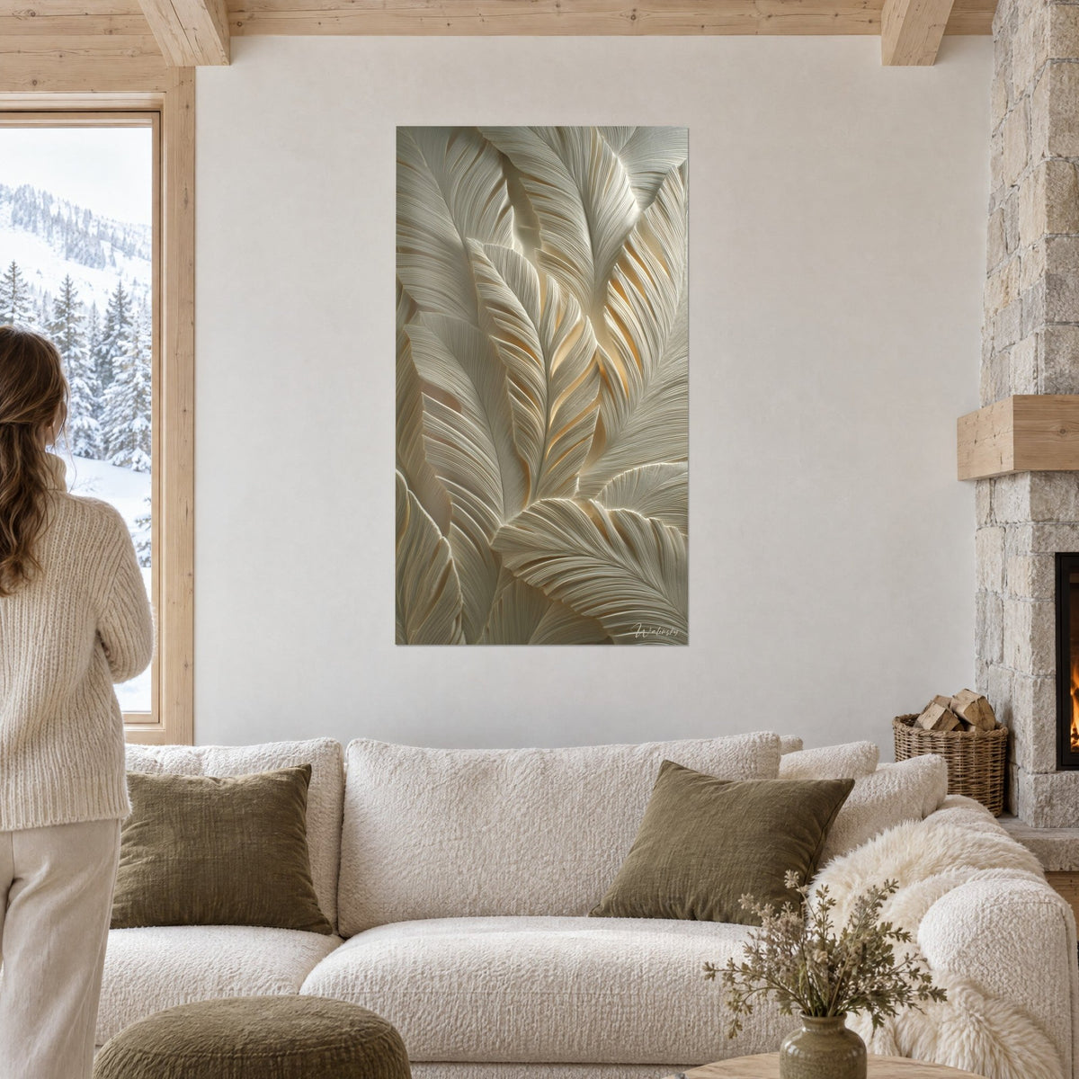 Tableau plumes sculptées ivoire et or pâle en relief, personne de dos devant, au-dessus d'un canapé dans un salon lumineux