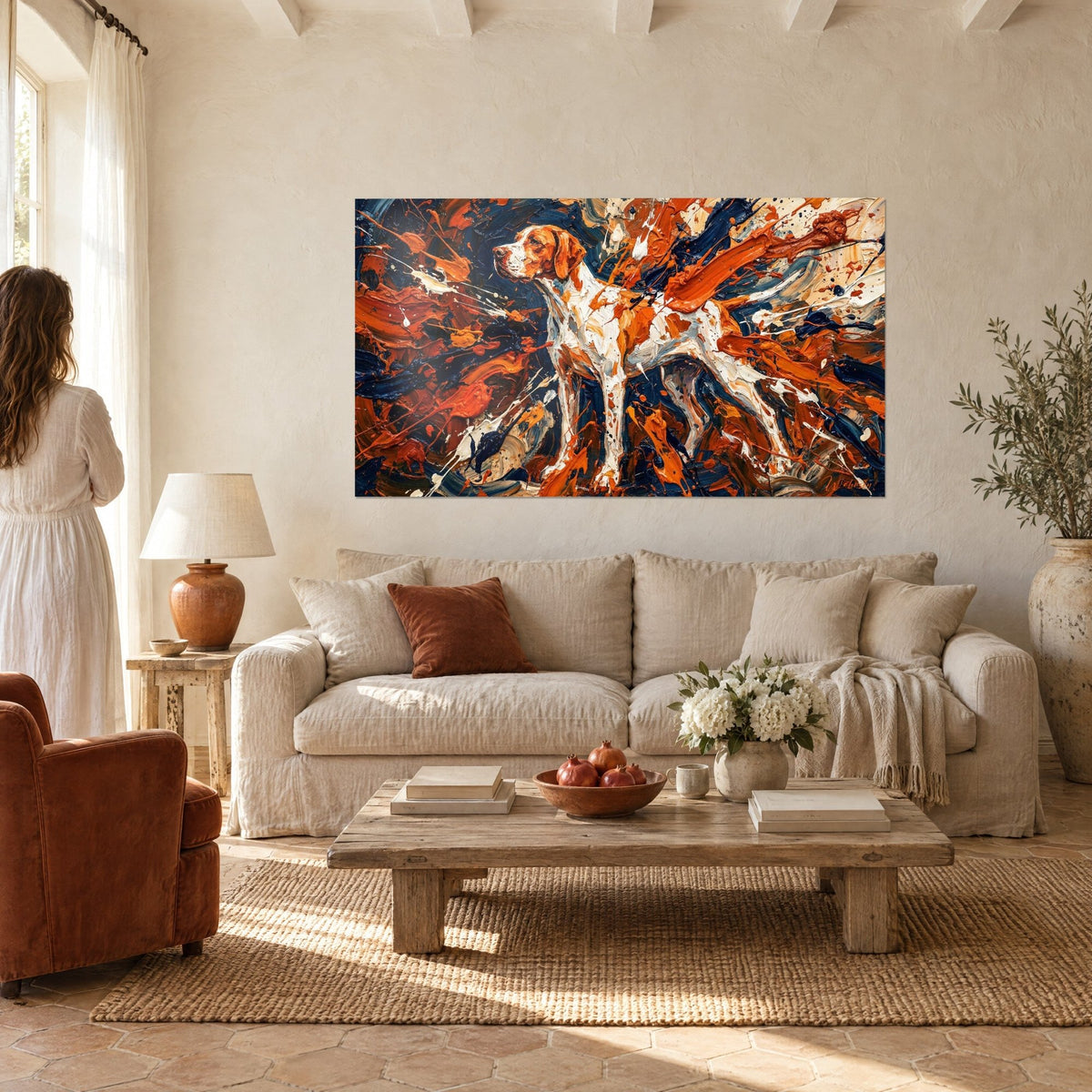 Tableau pointer anglais blanc et orange en arrêt, éclaboussures bleu nuit, femme de dos, au-dessus d'un canapé dans un salon lumineux